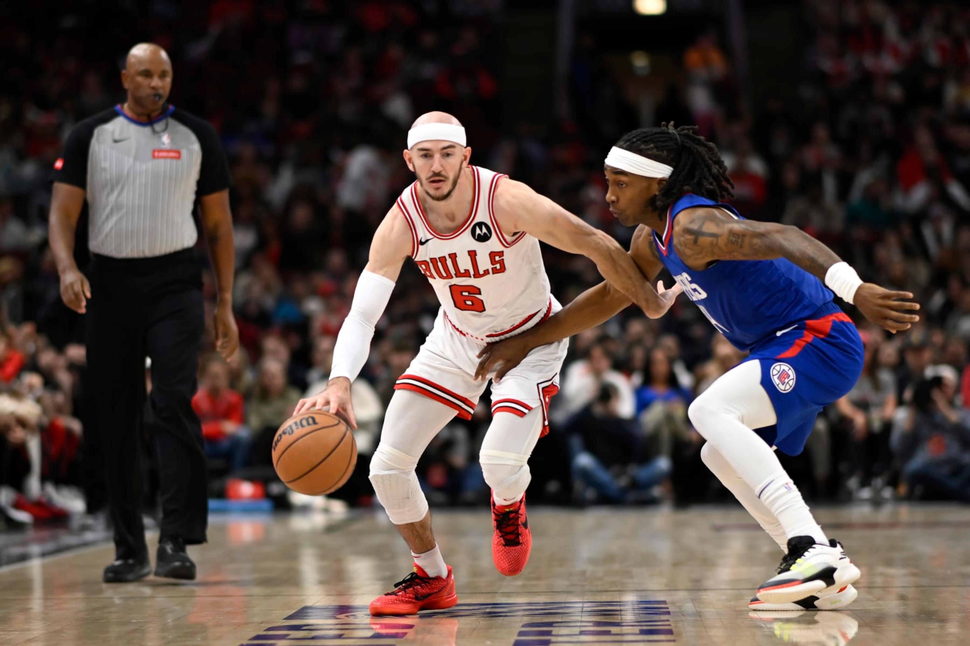 CHICAGO, ILLINOIS - MARCH 14: Alex Caruso #6 of the Chicago Bulls drives with the basketball in the first half against Terance Mann #14 of the LA Clippers at the United Center on March 14, 2024 in Chicago, Illinois. NOTE TO USER: User expressly acknowledges and agrees that, by downloading and or using this photograph, User is consenting to the terms and conditions of the Getty Images License Agreement. (Photo by Quinn Harris/Getty Images) CHICAGO, ILLINOIS - MARCH 14: Alex Caruso #6 of the Chicago Bulls drives with the basketball in the first half against Terance Mann #14 of the LA Clippers at the United Center on March 14, 2024 in Chicago, Illinois. NOTE TO USER: User expressly acknowledges and agrees that, by downloading and or using this photograph, User is consenting to the terms and conditions of the Getty Images License Agreement. (Photo by Quinn Harris/Getty Images)