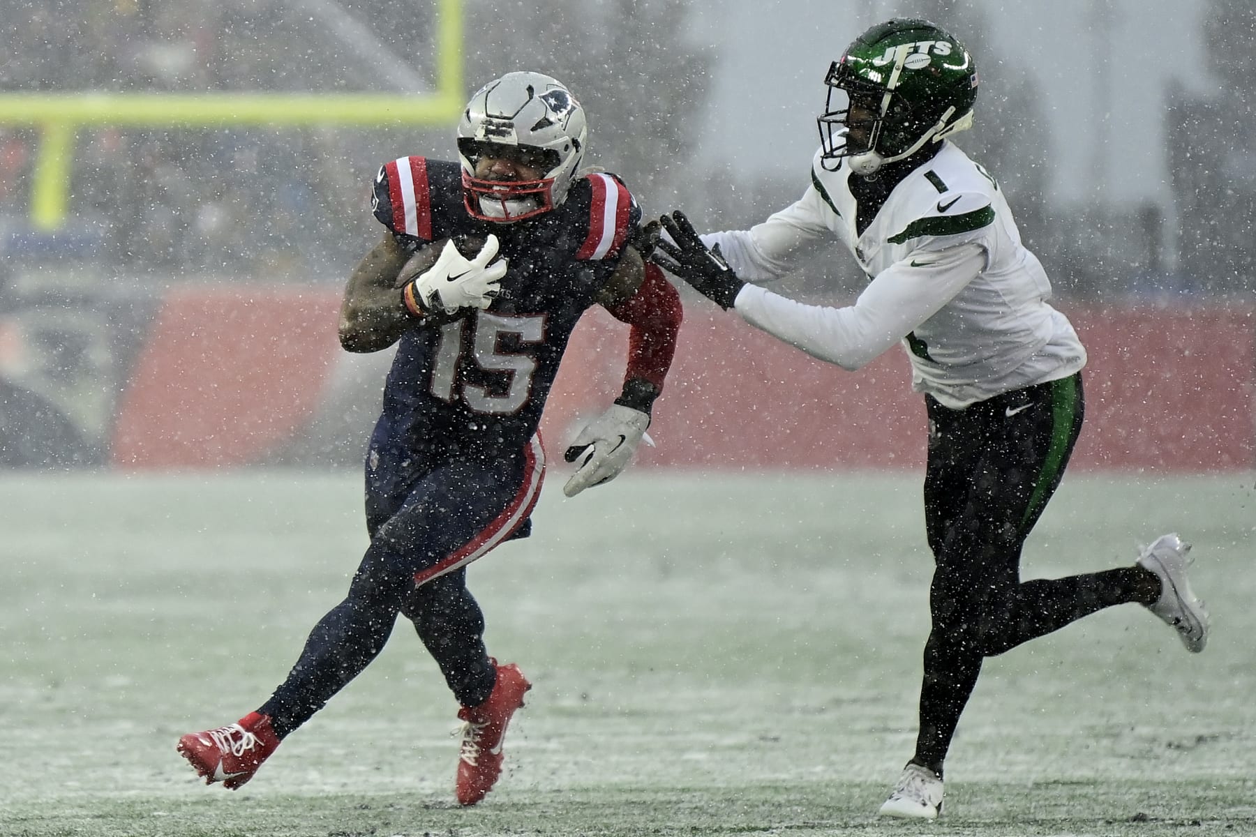 FOXBOROUGH, MASSACHUSETTS - JANUARY 07: Ezekiel Elliott #15 of the New England Patriots carries the ball, defended by Sauce Gardner #1 of the New York Jets in the second quarter during a game at Gillette Stadium on January 07, 2024 in Foxborough, Massachusetts. (Photo by Billie Weiss/Getty Images)