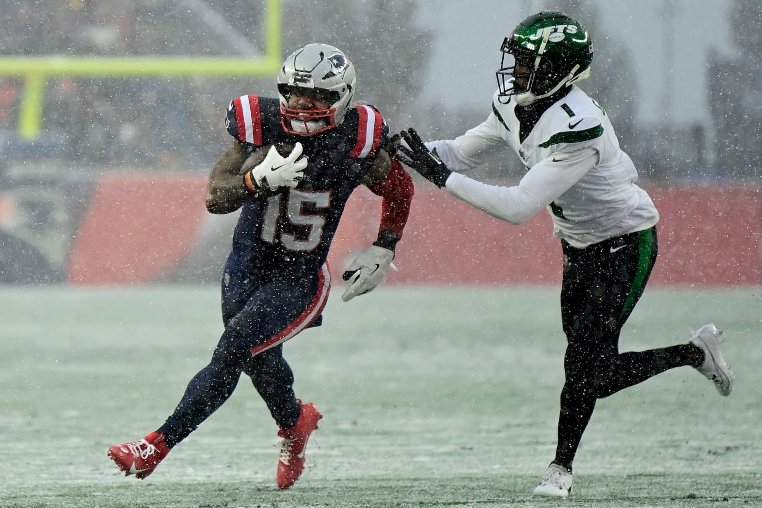 FOXBOROUGH, MASSACHUSETTS - JANUARY 07: Ezekiel Elliott #15 of the New England Patriots carries the ball, defended by Sauce Gardner #1 of the New York Jets in the second quarter during a game at Gillette Stadium on January 07, 2024 in Foxborough, Massachusetts. (Photo by Billie Weiss/Getty Images)