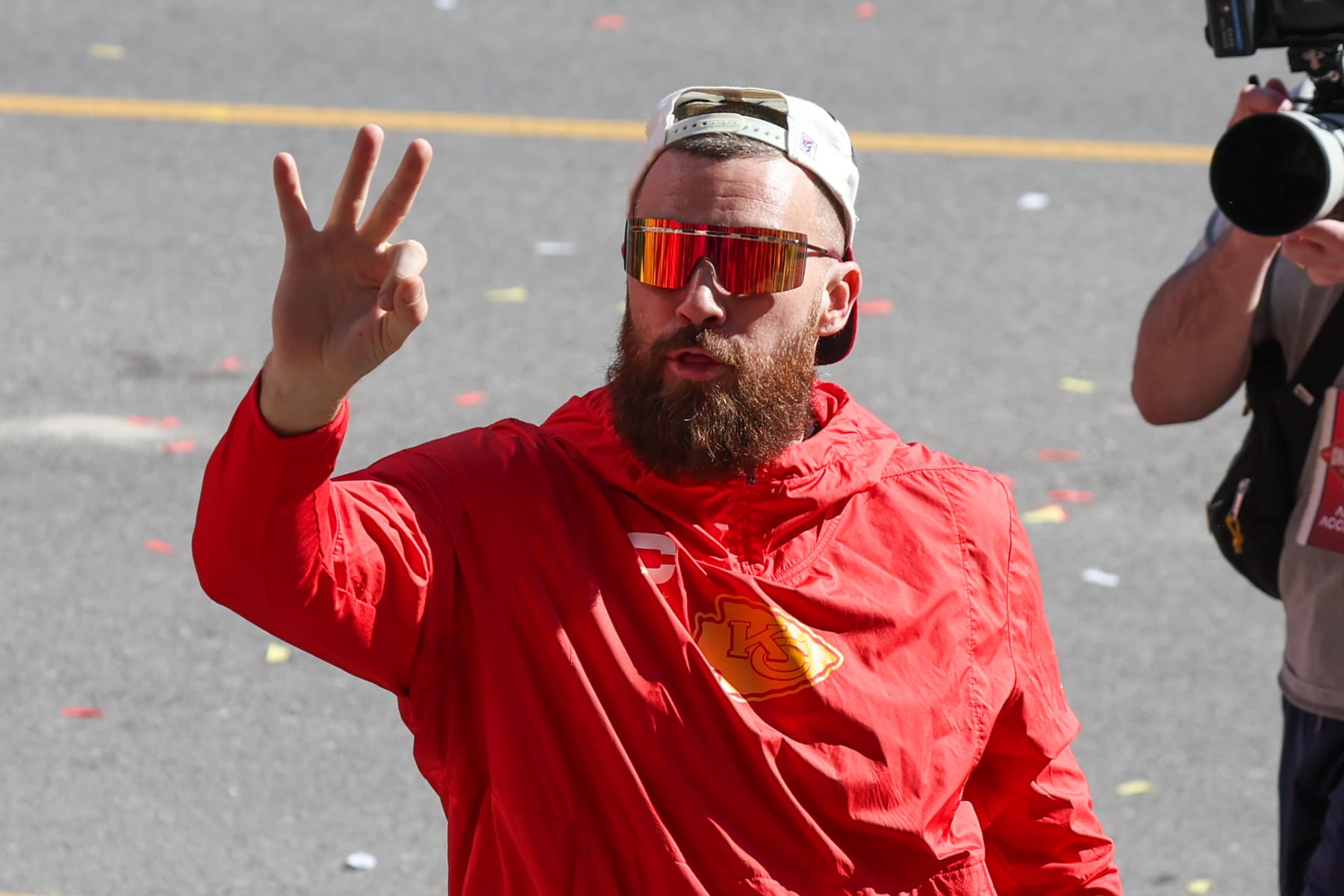 KANSAS CITY, MO - FEBRUARY 14: Travis Kelce wears a wrestling title belt and holds up three fingers to signal three titles during the Kansas City Chiefs Super Bowl LVIII Victory Parade on Feb 14, 2024 in Kansas City, MO. (Photo by Scott Winters/Icon Sportswire via Getty Images)