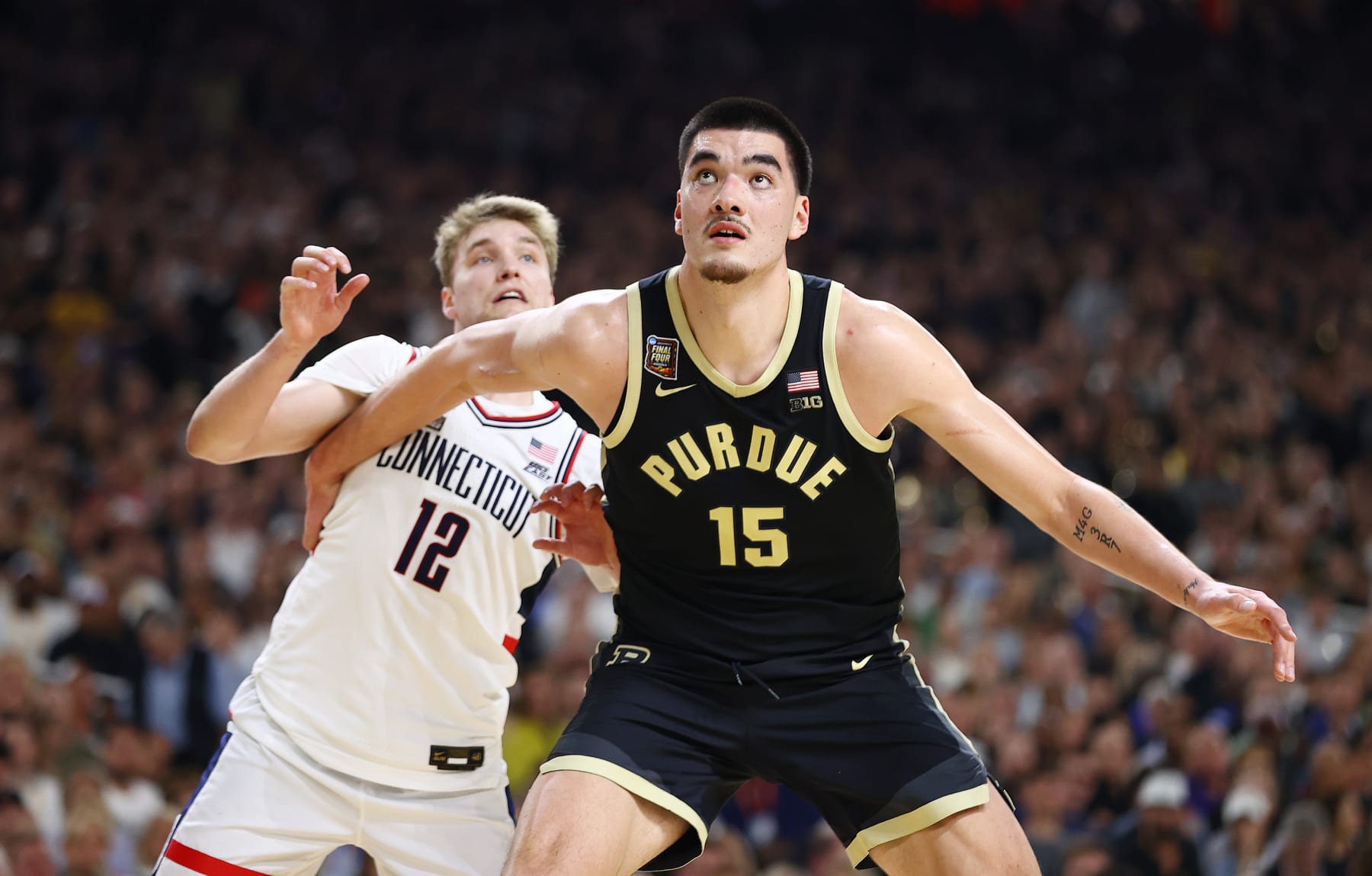 GLENDALE, ARIZONA - APRIL 08: Zach Edey #15 of the Purdue Boilermakers boxes out Cam Spencer #12 of the Connecticut Huskies during the second half in the NCAA Men's Basketball Tournament National Championship game at State Farm Stadium on April 08, 2024 in Glendale, Arizona. (Photo by Jamie Schwaberow/NCAA Photos via Getty Images)