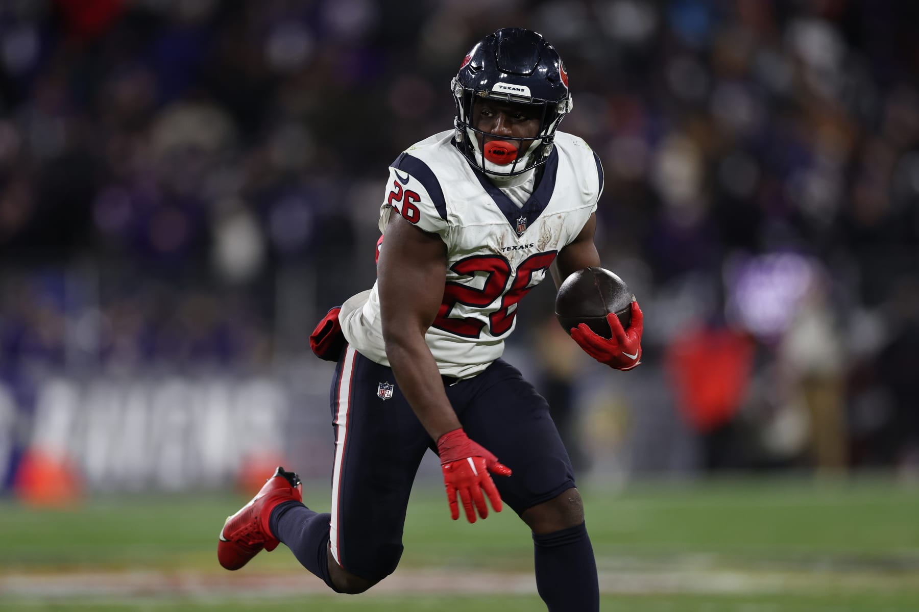 BALTIMORE, MARYLAND - JANUARY 20: Running back Devin Singletary #26 of the Houston Texans rushes against the Baltimore Ravens in the AFC Divisional Playoff game at M&T Bank Stadium on January 20, 2024 in Baltimore, Maryland. (Photo by Patrick Smith/Getty Images)
