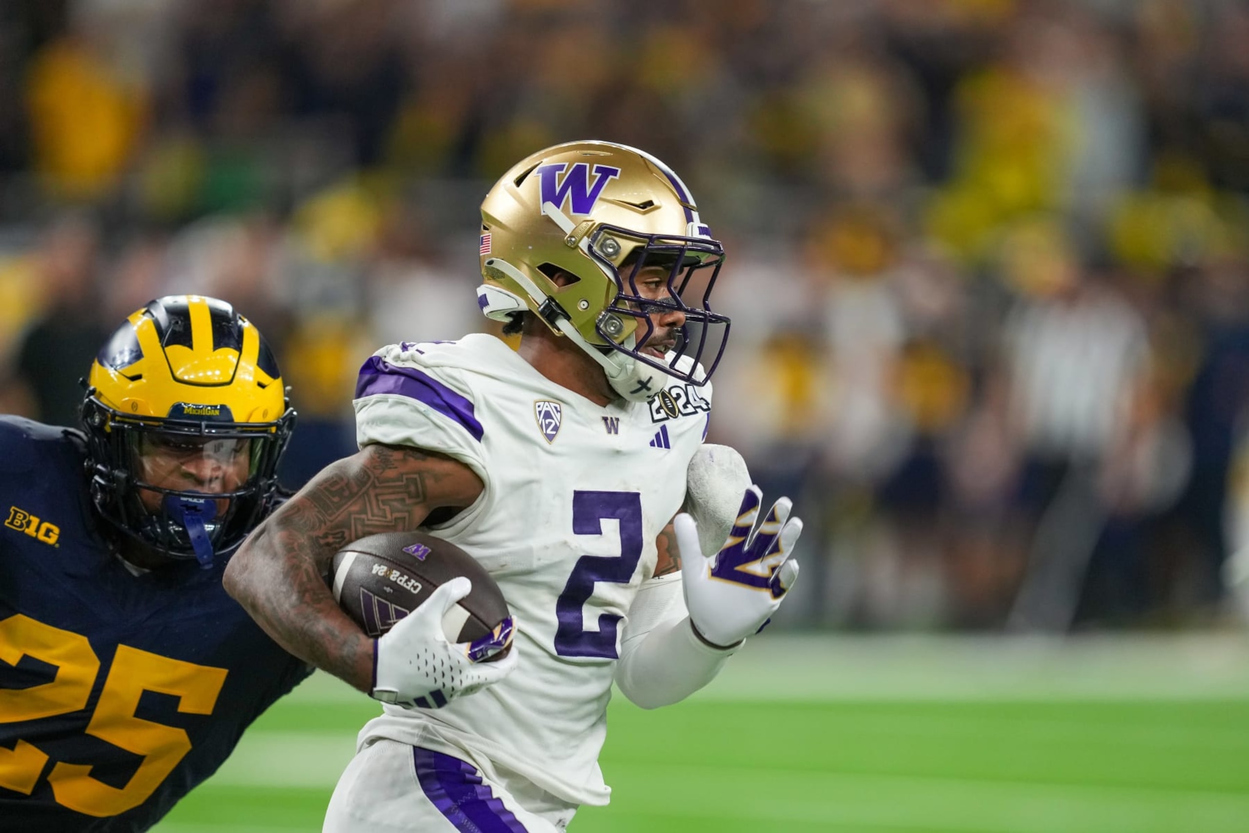 HOUSTON, TX - JANUARY 08: Washington Huskies wide receiver Ja'Lynn Polk (2) runs from Michigan Wolverines linebacker Junior Colson (25) during the CFP National Championship game between the Michigan Wolverines and Washington Huskies on January 8, 2024 at NRG Stadium in Houston, Texas. (Photo by Daniel Dunn/Icon Sportswire via Getty Images) HOUSTON, TX - JANUARY 08: Washington Huskies wide receiver Ja'Lynn Polk (2) runs from Michigan Wolverines linebacker Junior Colson (25) during the CFP National Championship game between the Michigan Wolverines and Washington Huskies on January 8, 2024 at NRG Stadium in Houston, Texas. (Photo by Daniel Dunn/Icon Sportswire via Getty Images)