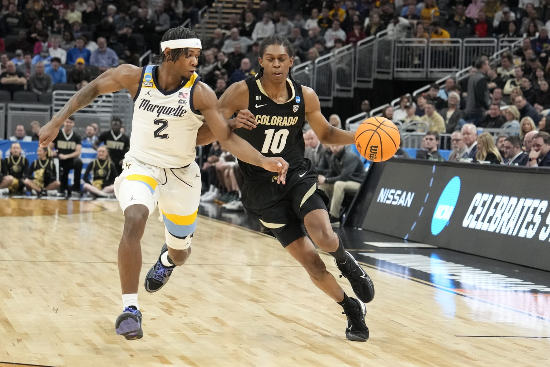 INDIANAPOLIS, INDIANA - MARCH 24: Cody Williams #10 of the Colorado Buffaloes dribbles the ball by Chase Ross #2 of the Marquette Golden Eagles during the Second Round NCAA Men's Basketball Tournament game at Gainbridge Fieldhouse on March 24, 2024 in Indianapolis, Indiana. (Photo by Mitchell Layton/Getty Images)