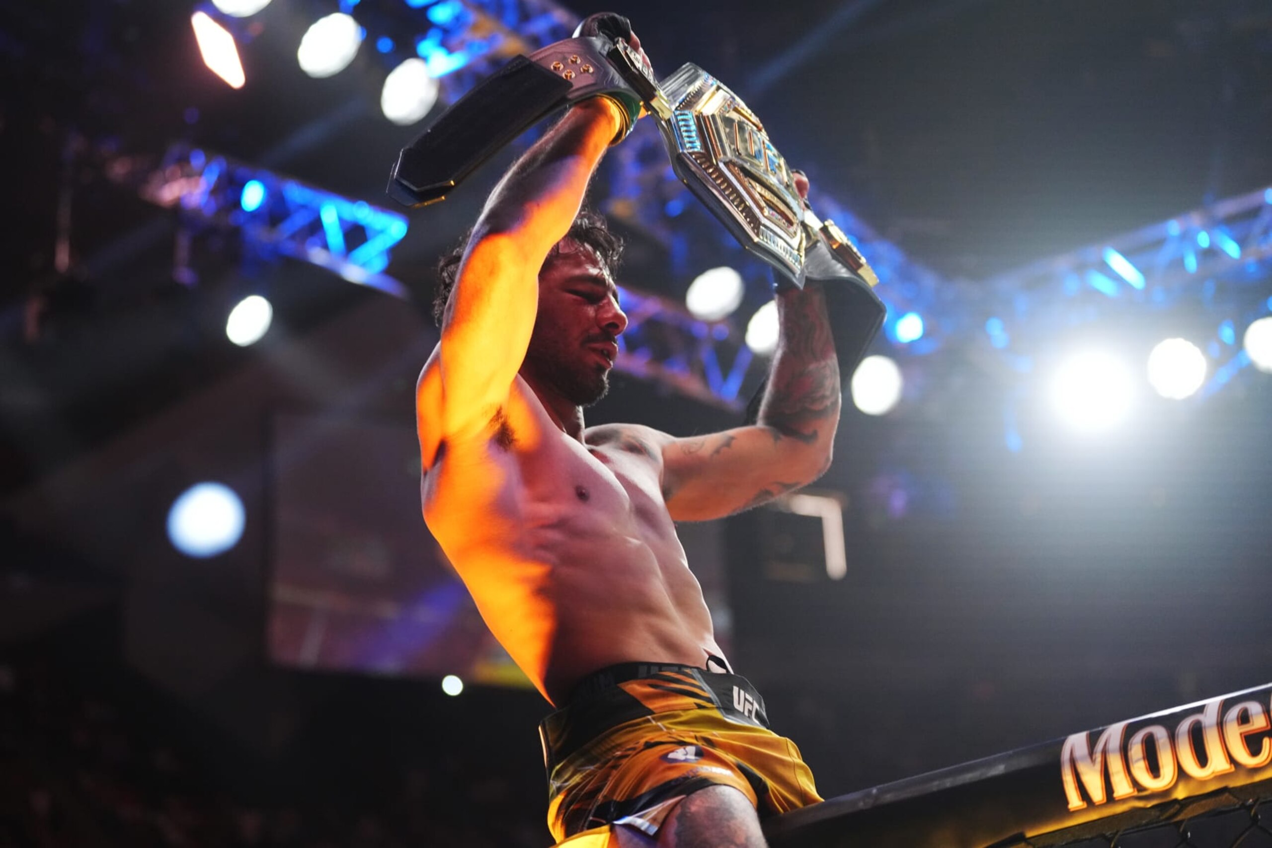 Alexandre Pantoja hoists the flyweight belt after defeating Brandon Moreno.