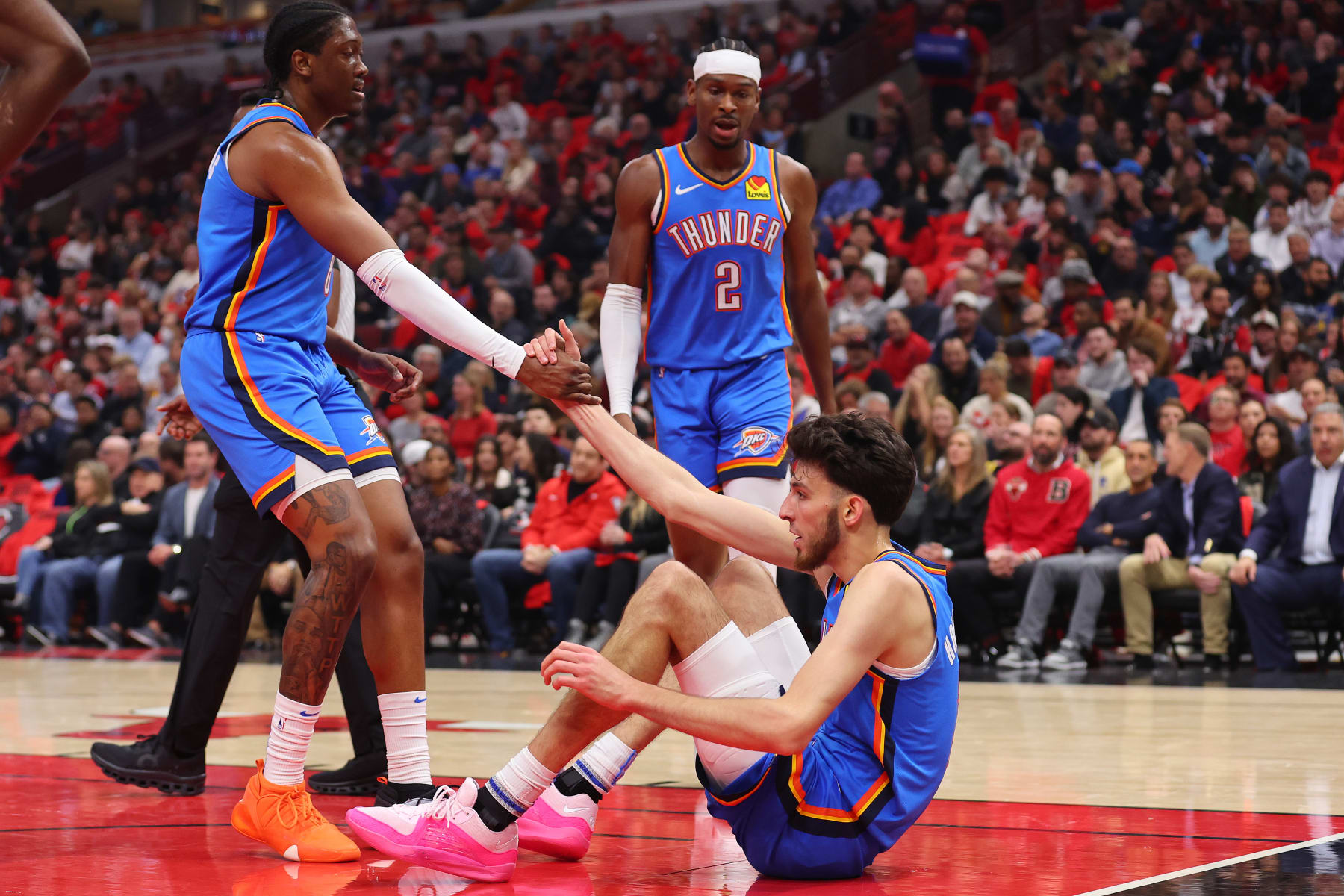 CHICAGO, ILLINOIS - OCTOBER 25: Chet Holmgren #7 of the Oklahoma City Thunder is helped up by Jalen Williams #8 and Shai Gilgeous-Alexander #2 against the Chicago Bulls during the first half at the United Center on October 25, 2023 in Chicago, Illinois. NOTE TO USER: User expressly acknowledges and agrees that, by downloading and or using this photograph, User is consenting to the terms and conditions of the Getty Images License Agreement. (Photo by Michael Reaves/Getty Images)