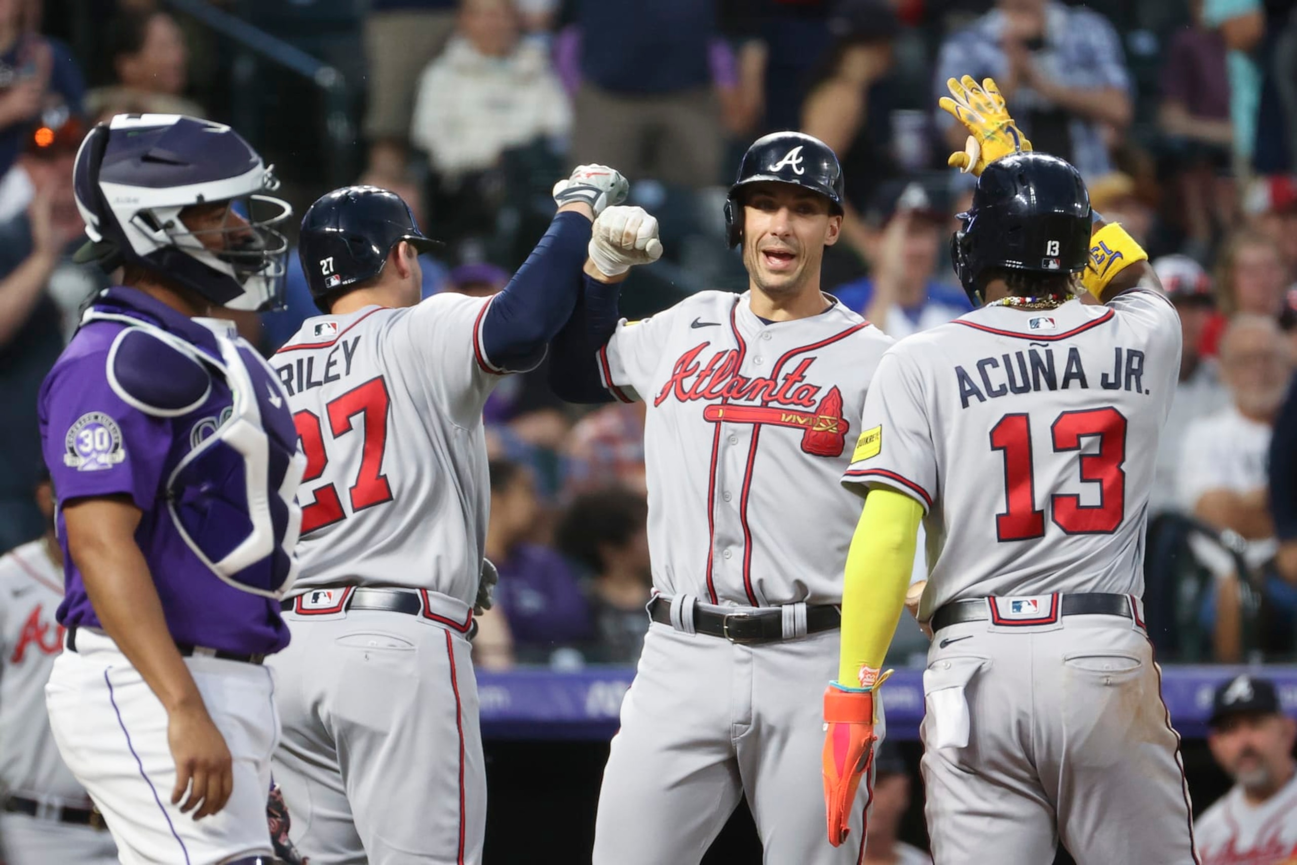 DENVER, COLORADO - AUGUST 28: (L-R) Austin Riley #27, Matt Olson #28, and Ronald Acuna Jr. #13 of the Atlanta Braves celebrate Riley's home run against the Colorado Rockies at Coors Field on August 28, 2023 in Denver, Colorado. (Photo by Tyler Schank/Clarkson Creative/Getty Images)