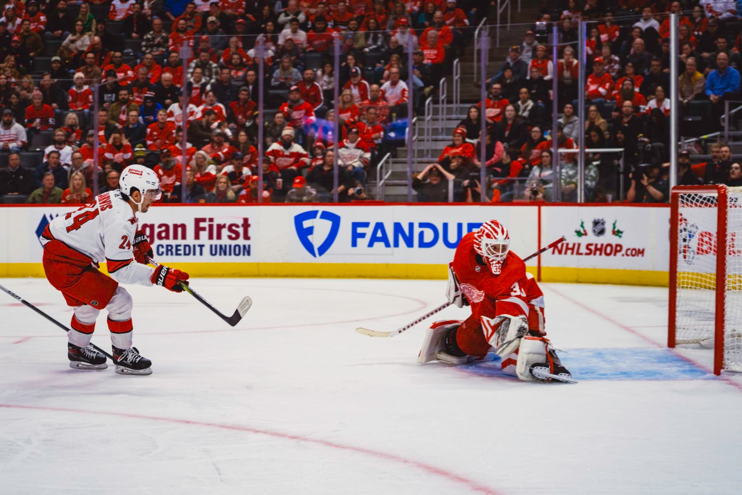 DETROIT, MI - DECEMBER 14: Seth Jarvis #24 of the Carolina Hurricanes shoots the puck wide of the net as goalie Ville Husso #35 of the Detroit Red Wings defends during the second period at Little Caesars Arena on December 14, 2023 in Detroit, Michigan. (Photo by Darren Clark/NHLI via Getty Images)