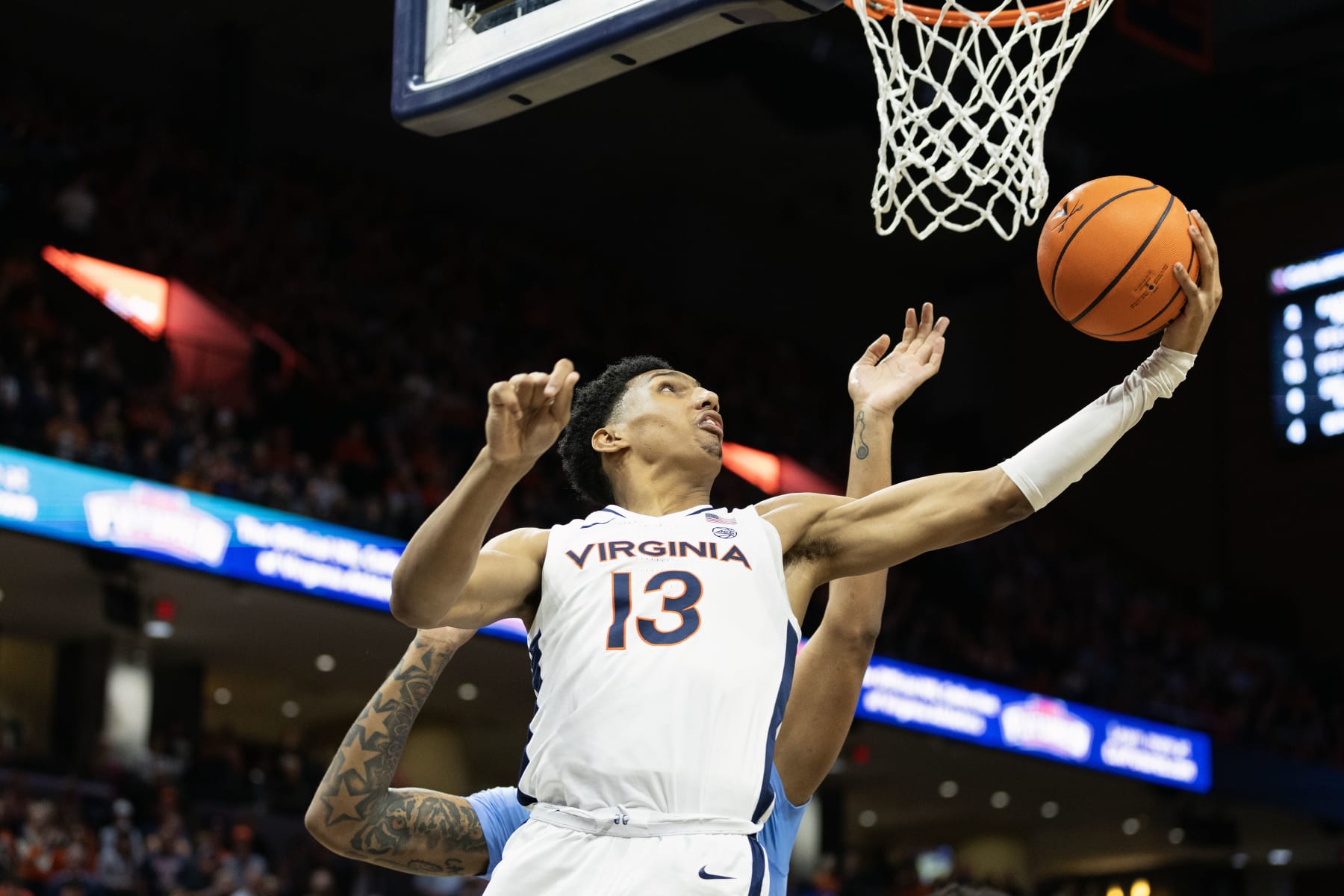 CHARLOTTESVILLE, VIRGINIA - FEBRUARY 24: Ryan Dunn #13 of the Virginia Cavaliers shoots past Armando Bacot #5 of the North Carolina Tar Heels in the second half during a game at John Paul Jones Arena on February 24, 2024 in Charlottesville, Virginia. (Photo by Ryan M. Kelly/Getty Images)