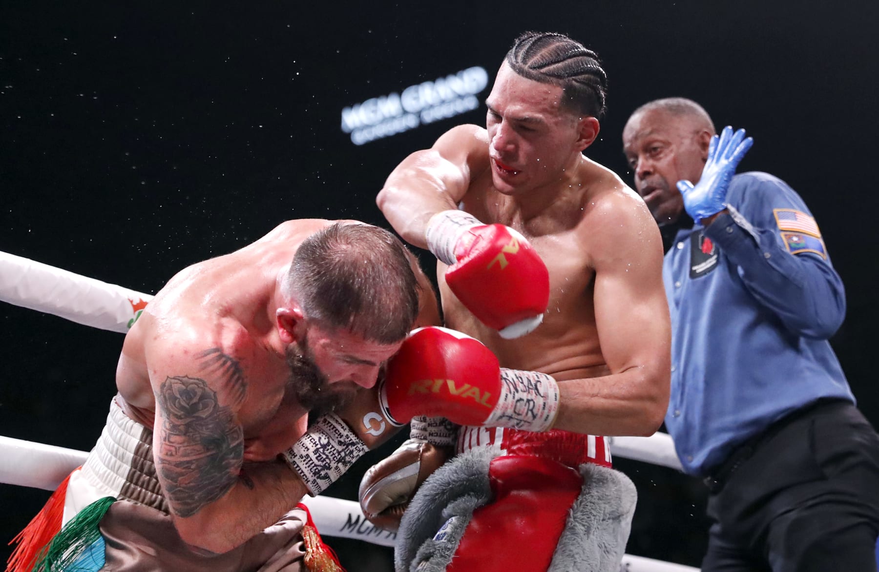 LAS VEGAS, NEVADA - MARCH 25: David Benavidez (C) punches Caleb Plant as referee Kenny Bayless looks on during a WBC super middleweight fight at MGM Grand Garden Arena on March 25, 2023 in Las Vegas, Nevada. Benavidez retained his WBC interim super middleweight title by unanimous decision.  (Photo by Steve Marcus/Getty Images)