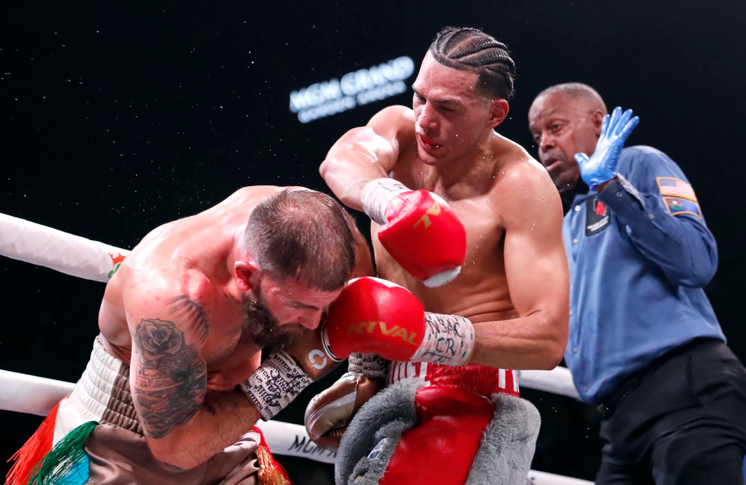 LAS VEGAS, NEVADA - MARCH 25: David Benavidez (C) punches Caleb Plant as referee Kenny Bayless looks on during a WBC super middleweight fight at MGM Grand Garden Arena on March 25, 2023 in Las Vegas, Nevada. Benavidez retained his WBC interim super middleweight title by unanimous decision.  (Photo by Steve Marcus/Getty Images)