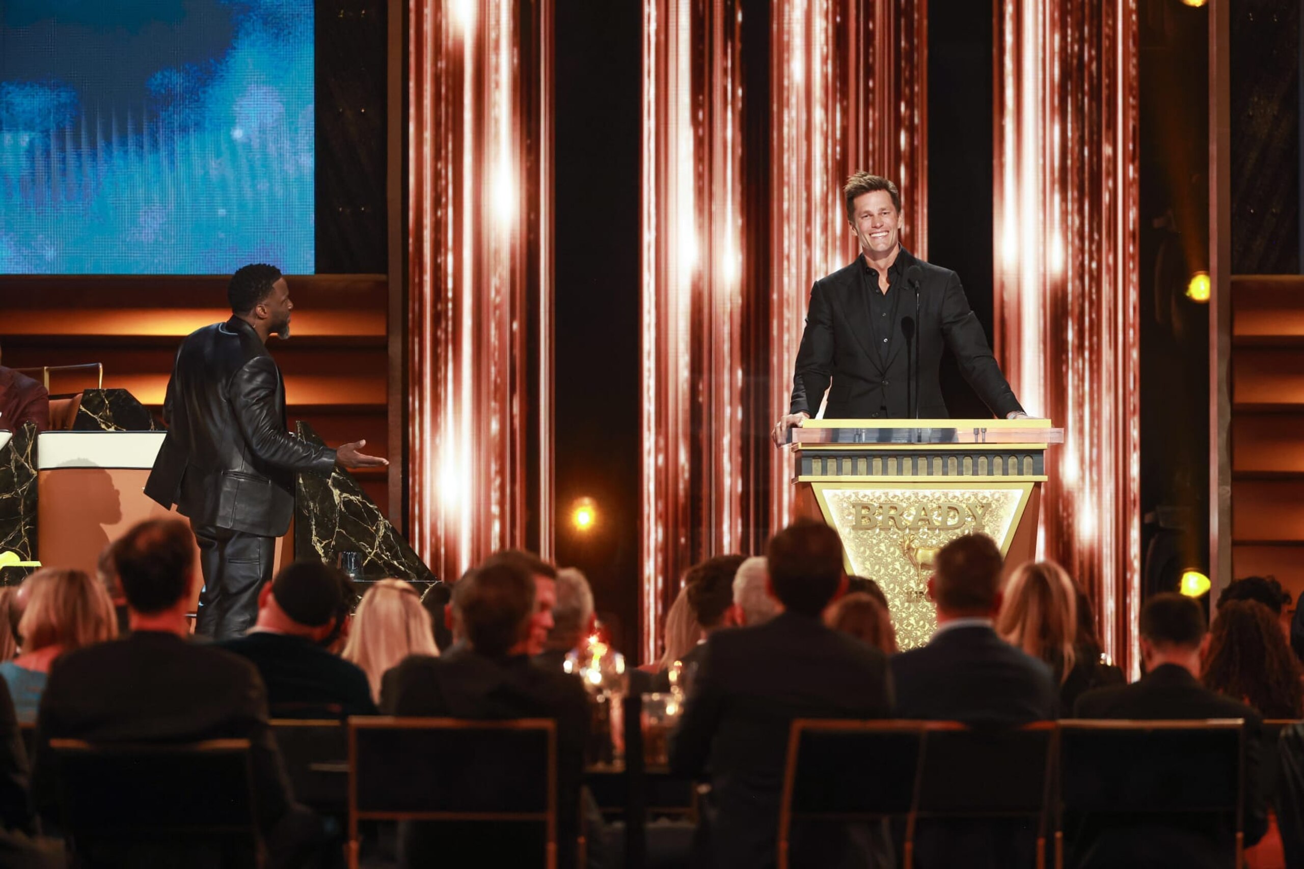 INGLEWOOD, CALIFORNIA - MAY 05: (L-R) Kevin Hart and Tom Brady speak onstage during G.R.O.A.T The Greatest Roast Of All Time: Tom Brady for the Netflix is a Joke Festival at The Kia Forum on May 05, 2024 in Inglewood, California.  (Photo by Matt Winkelmeyer/Getty Images for Netflix)