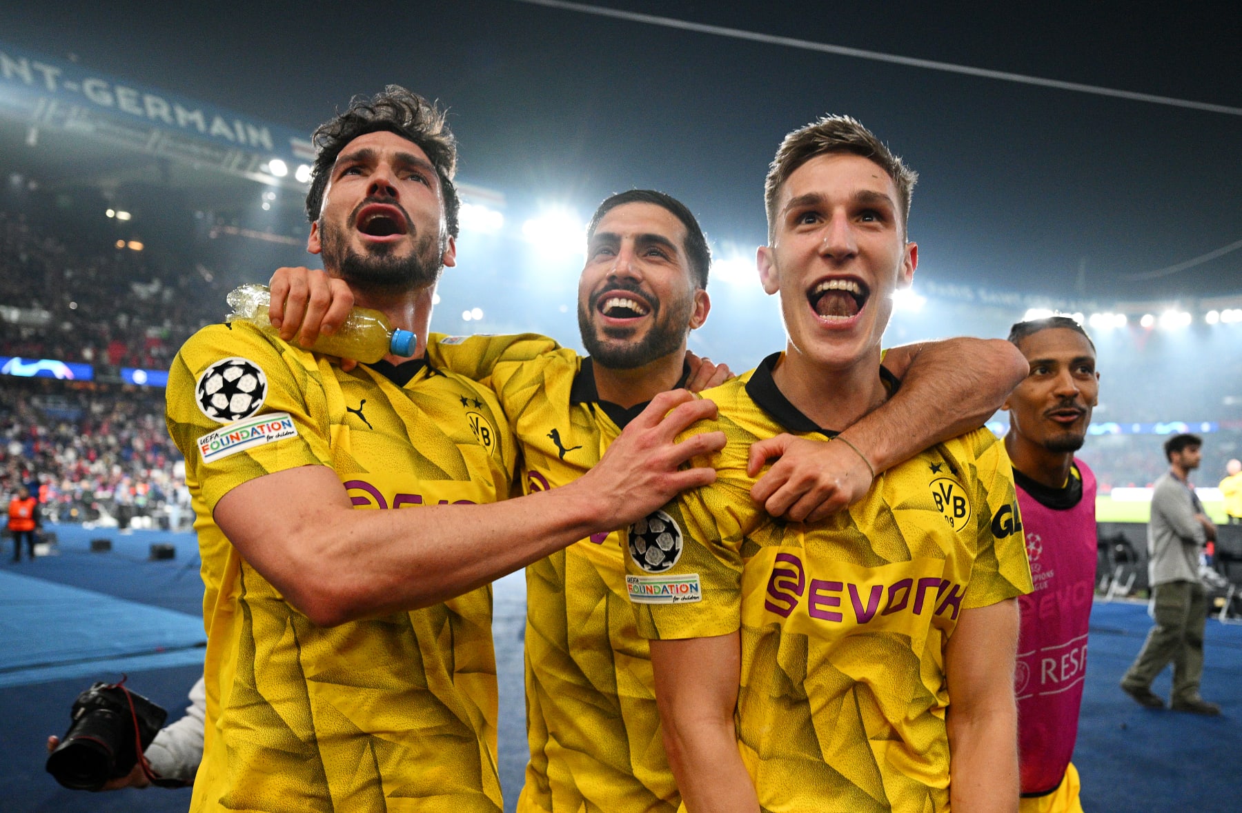 PARIS, FRANCE - MAY 07: Mats Hummels, Emre Can and Nico Schlotterbeck of Borussia Dortmund celebrate victory in front of fans of Borussia Dortmund after defeating Paris Saint-Germain during the UEFA Champions League semi-final second leg match between Paris Saint-Germain and Borussia Dortmund at Parc des Princes on May 07, 2024 in Paris, France.  (Photo by Matthias Hangst/Getty Images)