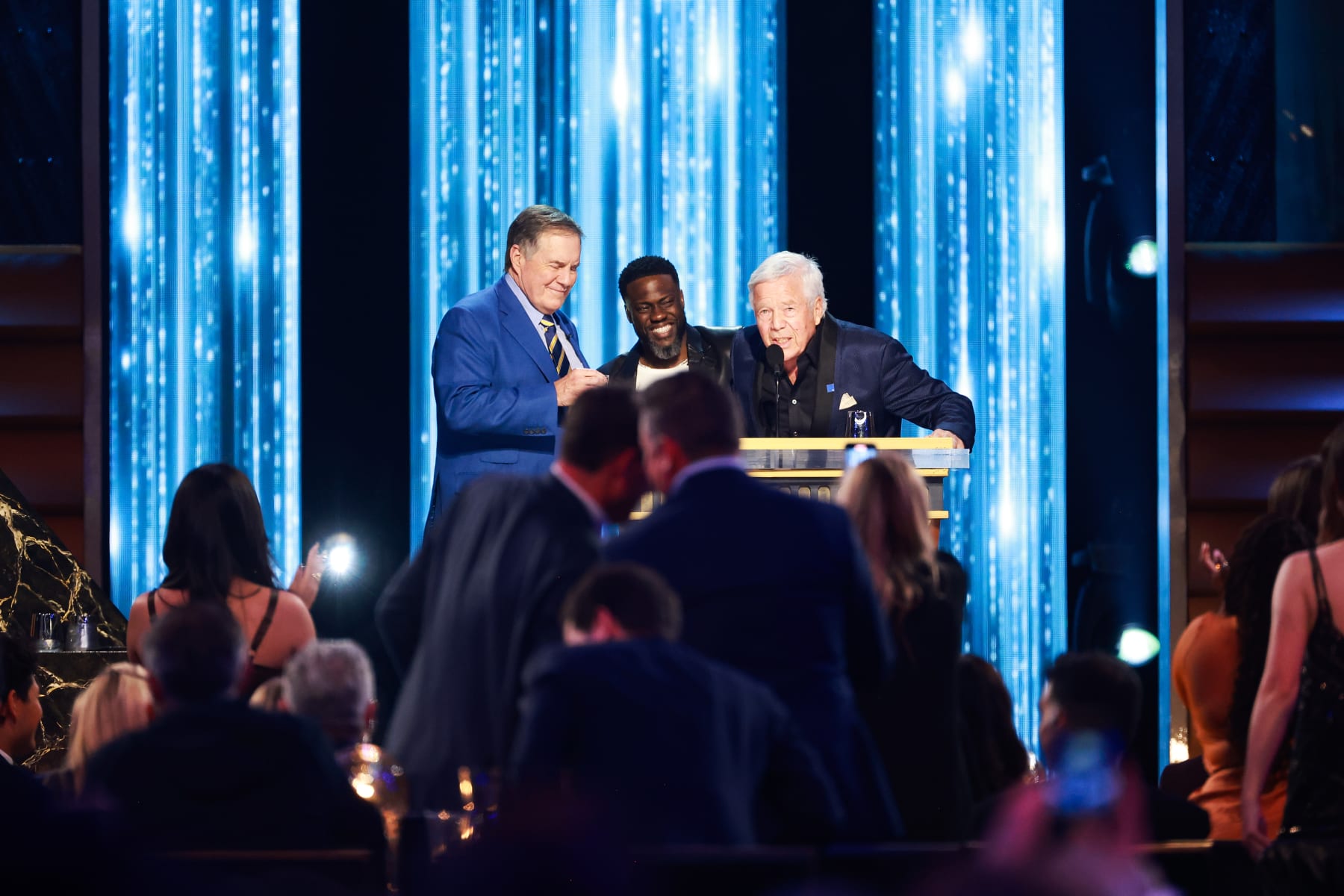 INGLEWOOD, CALIFORNIA - MAY 05: (L-R) Bill Belichick, Kevin Hart and Robert Kraft speak onstage during G.R.O.A.T The Greatest Roast Of All Time: Tom Brady for the Netflix is a Joke Festival at The Kia Forum on May 05, 2024 in Inglewood, California.  (Photo by Matt Winkelmeyer/Getty Images for Netflix)