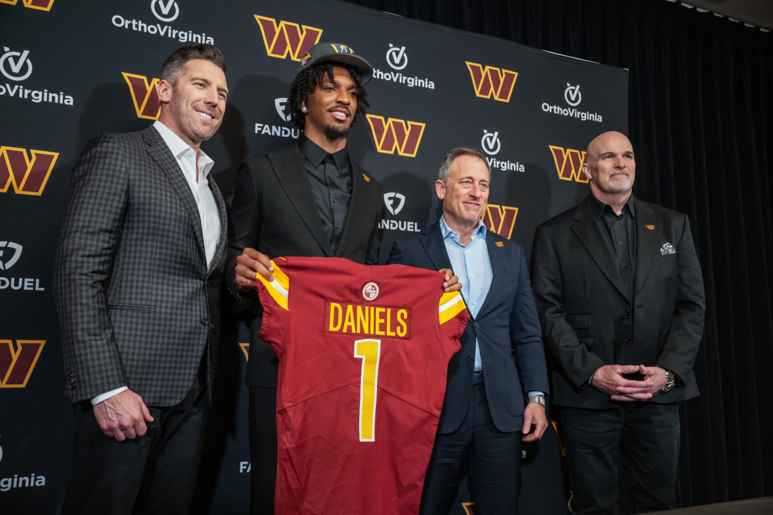 ASHBURN, VA - APRIL 26: Quarterback Jayden Daniels poses with Commanders head coach Dan Quinn, right, Commanders owner Josh Harris and Commanders general manager Adam Peters following a press conference at Commanders Park in Ashburn, VA on April 26, 2024. (Photo by Craig Hudson for The Washington Post via Getty Images)