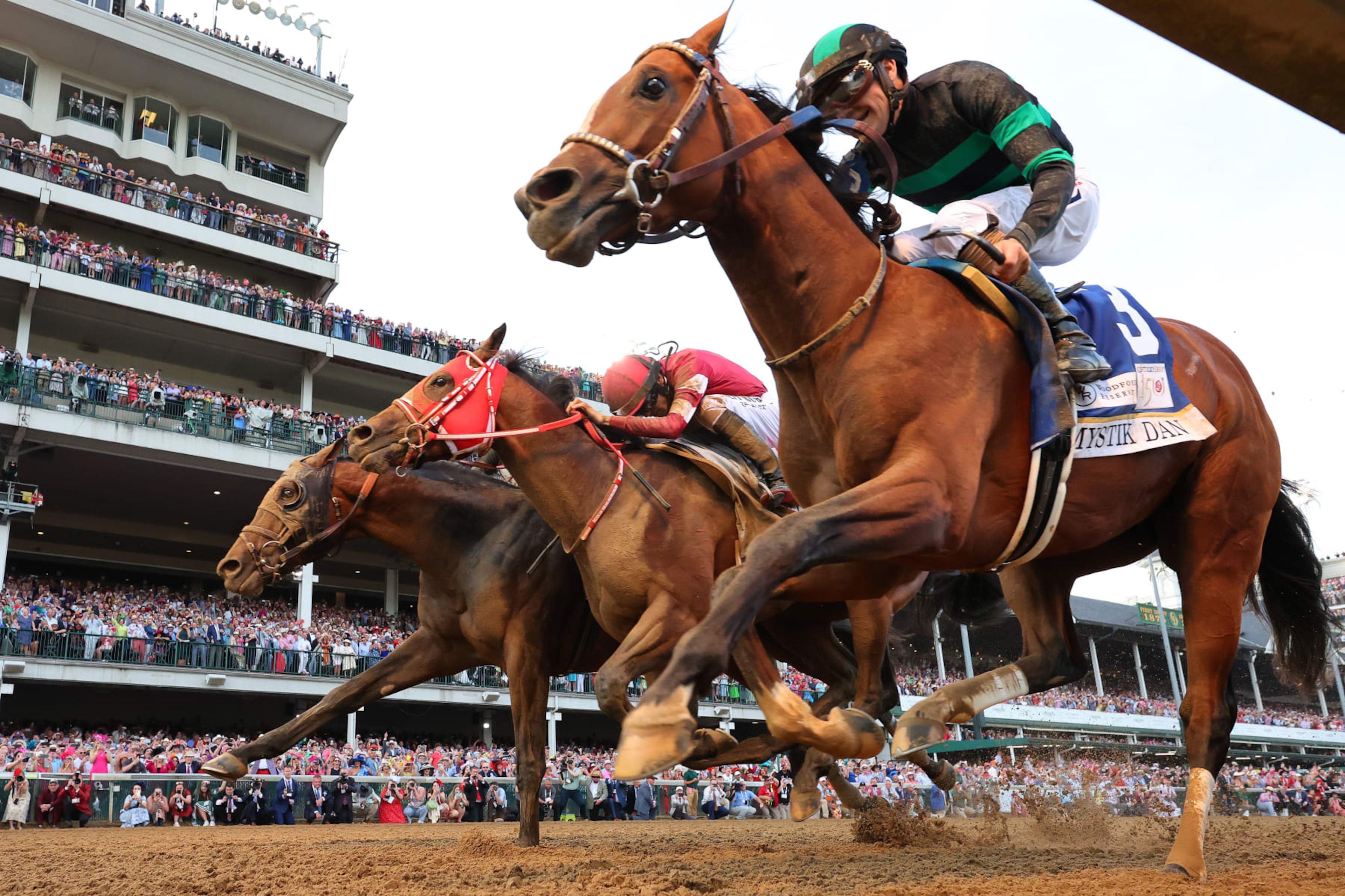 LOUISVILLE, KENTUCKY - MAY 04: Mystik Dan #3, ridden by jockey Brian J. Hernandez Jr. (R), crosses the finish line ahead of Sierra Leone #2, ridden by jockey Tyler Gaffalione and Forever Young, ridden by jockey Ryusei Sakai to win the 150th running of the Kentucky Derby at Churchill Downs on May 04, 2024 in Louisville, Kentucky. (Photo by Michael Reaves/Getty Images) LOUISVILLE, KENTUCKY - MAY 04: Mystik Dan #3, ridden by jockey Brian J. Hernandez Jr. (R), crosses the finish line ahead of Sierra Leone #2, ridden by jockey Tyler Gaffalione and Forever Young, ridden by jockey Ryusei Sakai to win the 150th running of the Kentucky Derby at Churchill Downs on May 04, 2024 in Louisville, Kentucky. (Photo by Michael Reaves/Getty Images)