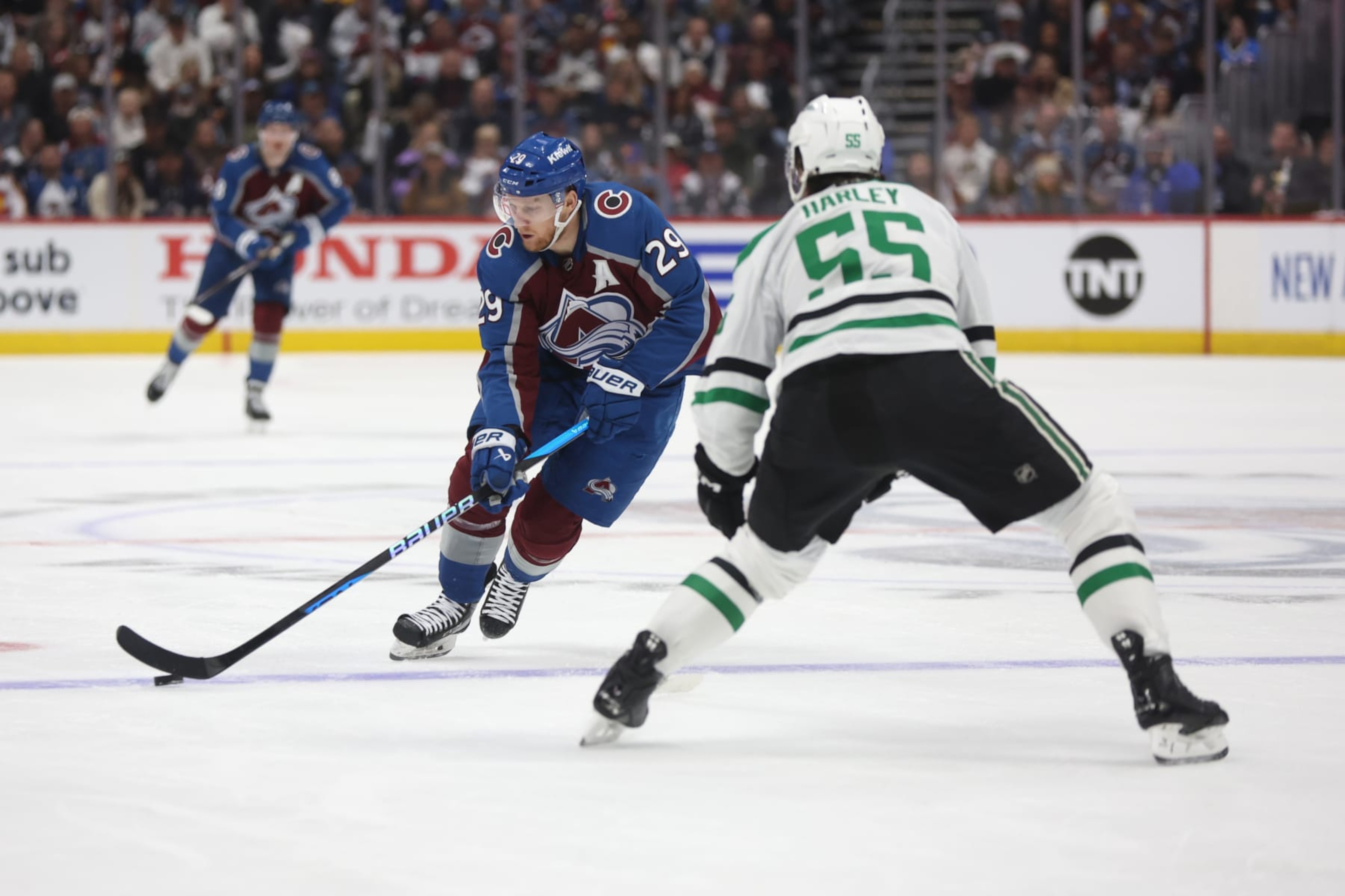 DENVER, COLORADO - MAY 11: Nathan MacKinnon #29 of the Colorado Avalanche skates with the puck against Thomas Harley #55 of the Dallas Stars during the second period in Game Three of the Second Round of the 2024 Stanley Cup Playoffs at Ball Arena on May 11, 2024 in Denver, Colorado. (Photo by Matthew Stockman/Getty Images) DENVER, COLORADO - MAY 11: Nathan MacKinnon #29 of the Colorado Avalanche skates with the puck against Thomas Harley #55 of the Dallas Stars during the second period in Game Three of the Second Round of the 2024 Stanley Cup Playoffs at Ball Arena on May 11, 2024 in Denver, Colorado. (Photo by Matthew Stockman/Getty Images)