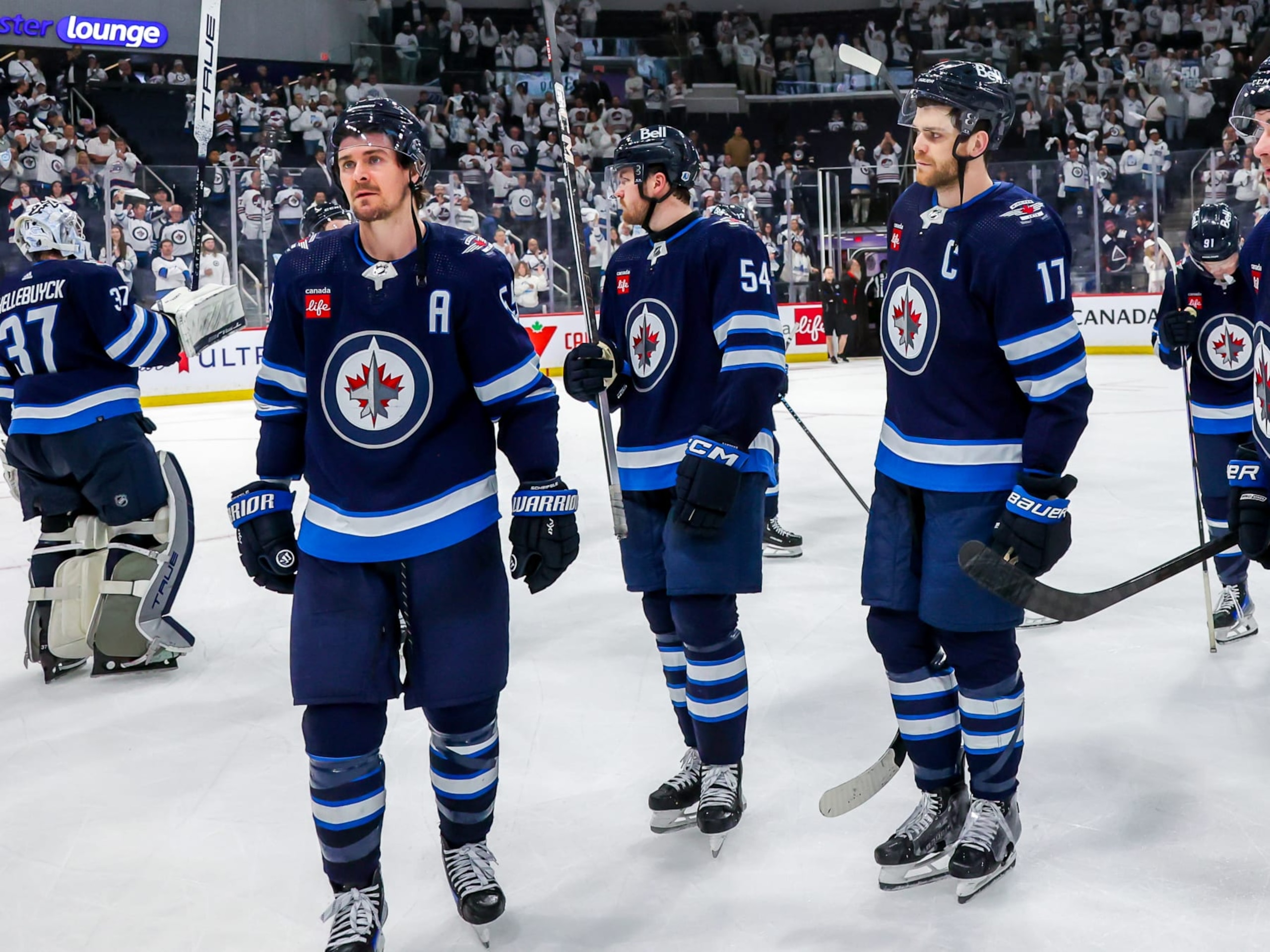 WINNIPEG, CANADA - APRIL 30: Mark Scheifele #55, Dylan Samberg #54, and Adam Lowry #17 of the Winnipeg Jets look on in disappointment following a 6-3 loss to the Colorado Avalanche in Game Five of the First Round of the 2024 Stanley Cup Playoffs at Canada Life Centre on April 30, 2024 in Winnipeg, Manitoba, Canada. (Photo by Jonathan Kozub/NHLI via Getty Images)