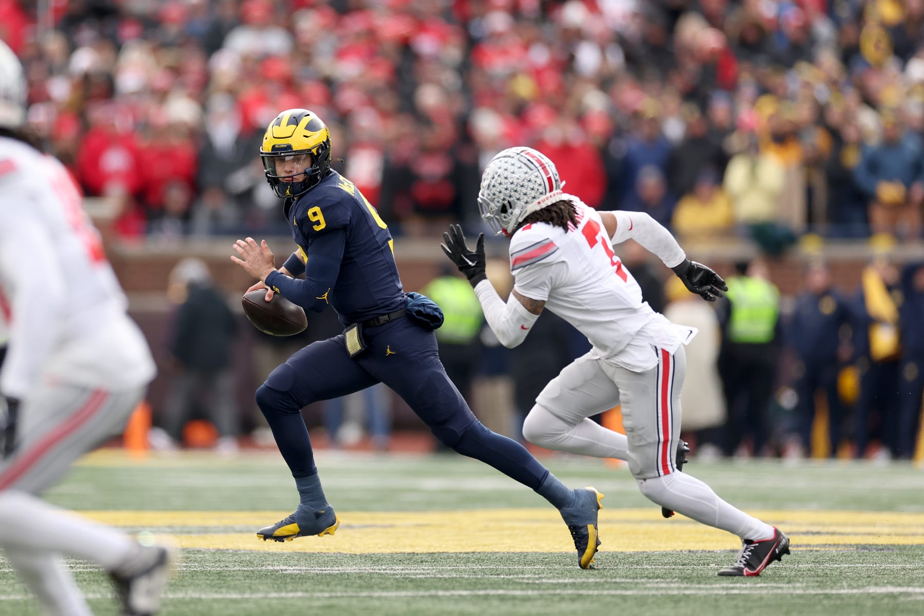 ANN ARBOR, MICHIGAN - NOVEMBER 25: J.J. McCarthy #9 of the Michigan Wolverines is pressured by Jordan Hancock #7 of the Ohio State Buckeyes at Michigan Stadium on November 25, 2023 in Ann Arbor, Michigan. (Photo by Ezra Shaw/Getty Images)