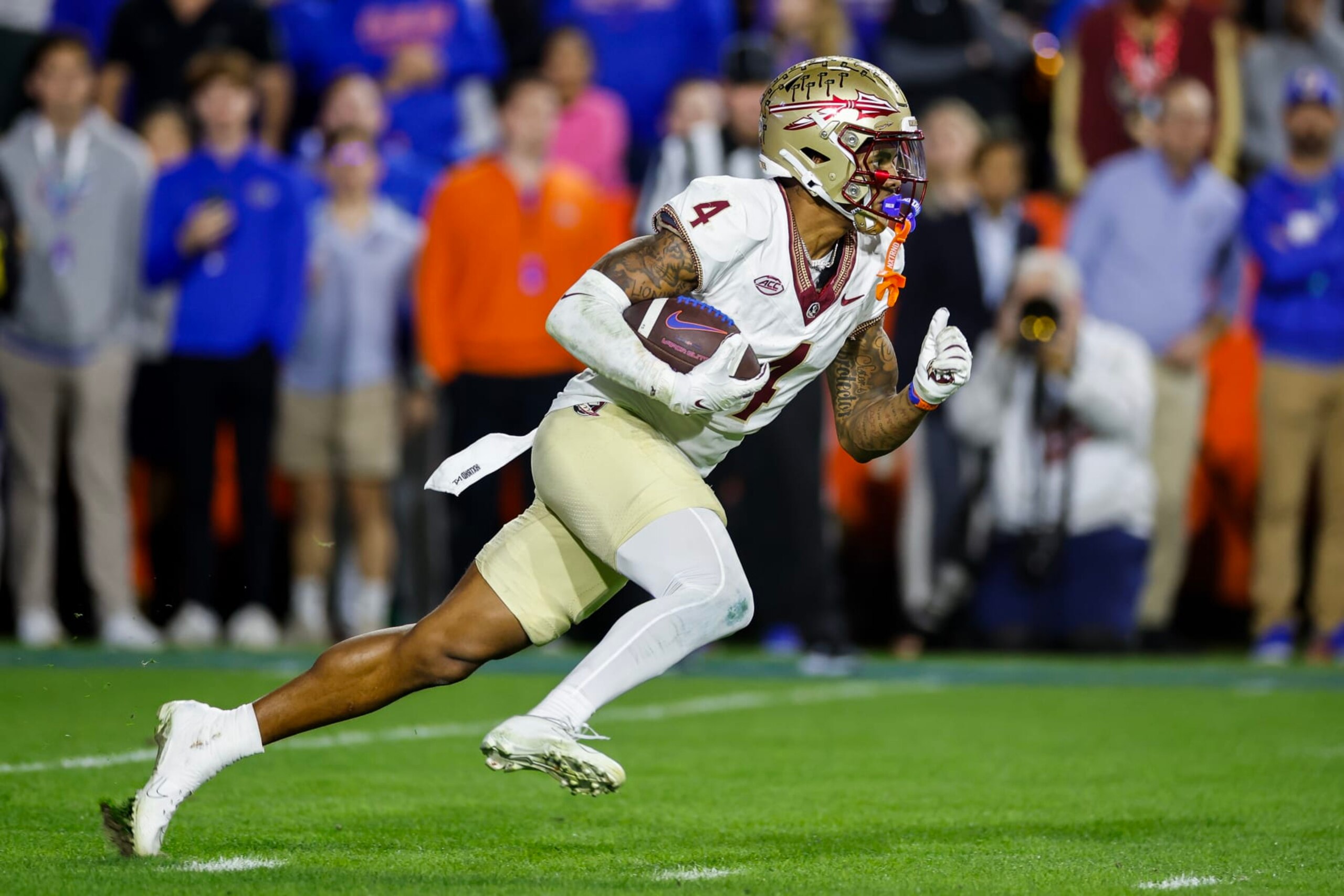 GAINESVILLE, FLORIDA - NOVEMBER 25: Keon Coleman #4 of the Florida State Seminoles runs with the ball  during the second half of a game against the Florida Gators at Ben Hill Griffin Stadium on November 25, 2023 in Gainesville, Florida. (Photo by James Gilbert/Getty Images)