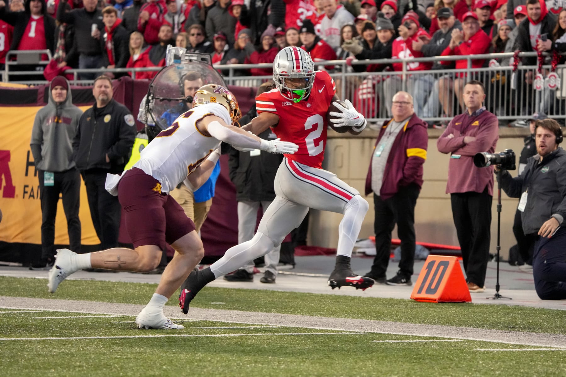 COLUMBUS, OHIO - NOVEMBER 18: Wide receiver Emeka Egbuka #2 of the Ohio State Buckeyes stiff arms defensive back Coleman Bryson #16 of the Minnesota Golden Gophers as he carries the ball during the second quarter at Ohio Stadium on November 18, 2023 in Columbus, Ohio. (Photo by Jason Mowry/Getty Images)