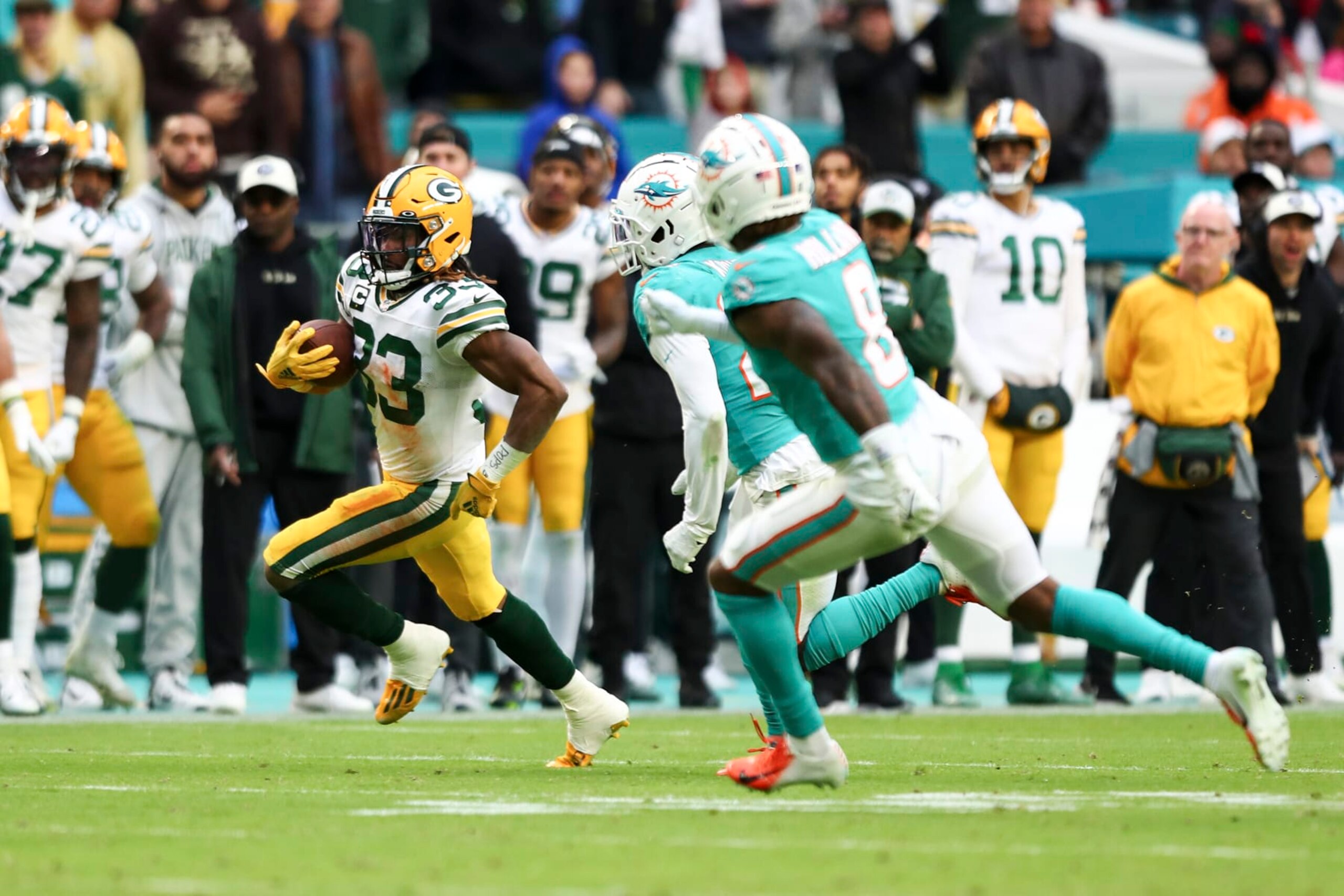 MIAMI GARDENS, FL - DECEMBER 25: Aaron Jones #33 of the Green Bay Packers carries the ball during an NFL football game against the Miami Dolphins, Sunday at Hard Rock Stadium on December 25, 2023 in Miami Gardens, Florida. (Photo by Kevin Sabitus/Getty Images)