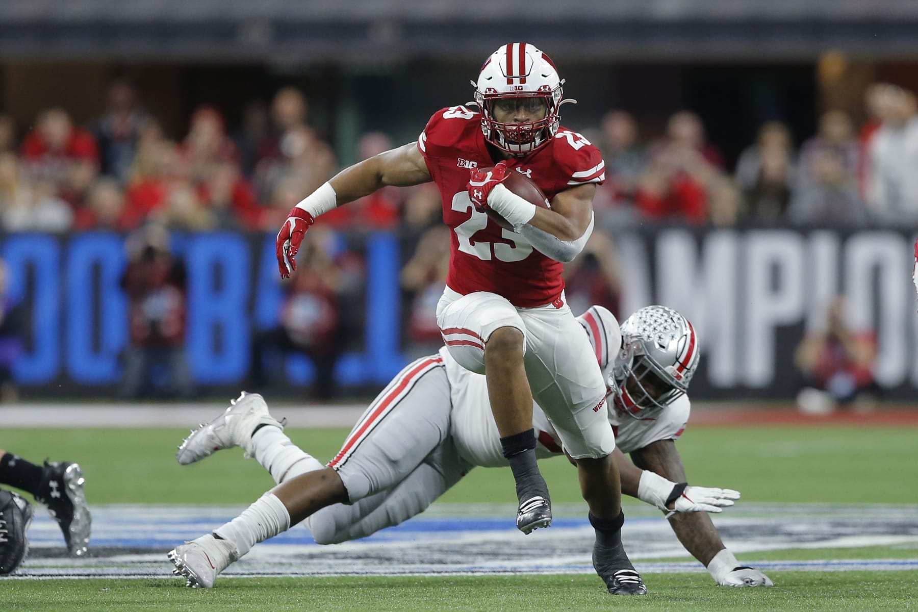 INDIANAPOLIS, IN - DECEMBER 07: Wisconsin Badgers running back Jonathan Taylor (23) hits the hole an goes for a nice gain during the Big 10 Championship game between the Wisconsin Badgers and Ohio State Buckeyes on December 7, 2019, at Lucas Oil Stadium in Indianapolis, IN.(Photo by Jeffrey Brown/Icon Sportswire via Getty Images)
