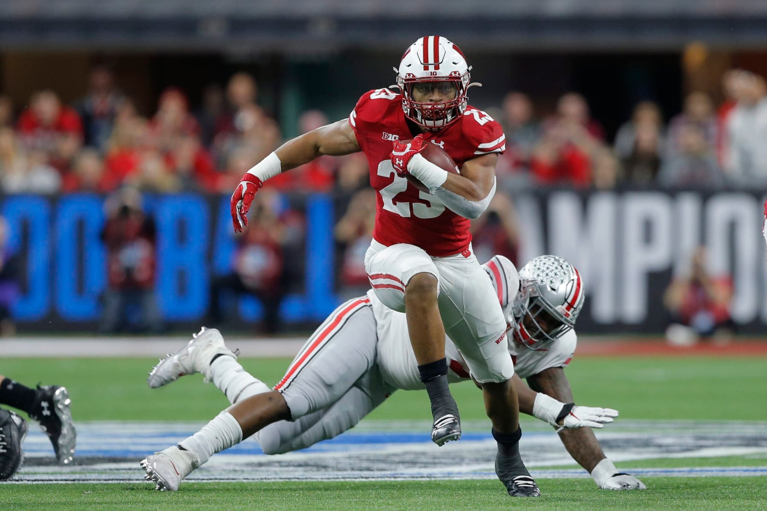 INDIANAPOLIS, IN - DECEMBER 07: Wisconsin Badgers running back Jonathan Taylor (23) hits the hole an goes for a nice gain during the Big 10 Championship game between the Wisconsin Badgers and Ohio State Buckeyes on December 7, 2019, at Lucas Oil Stadium in Indianapolis, IN.(Photo by Jeffrey Brown/Icon Sportswire via Getty Images)
