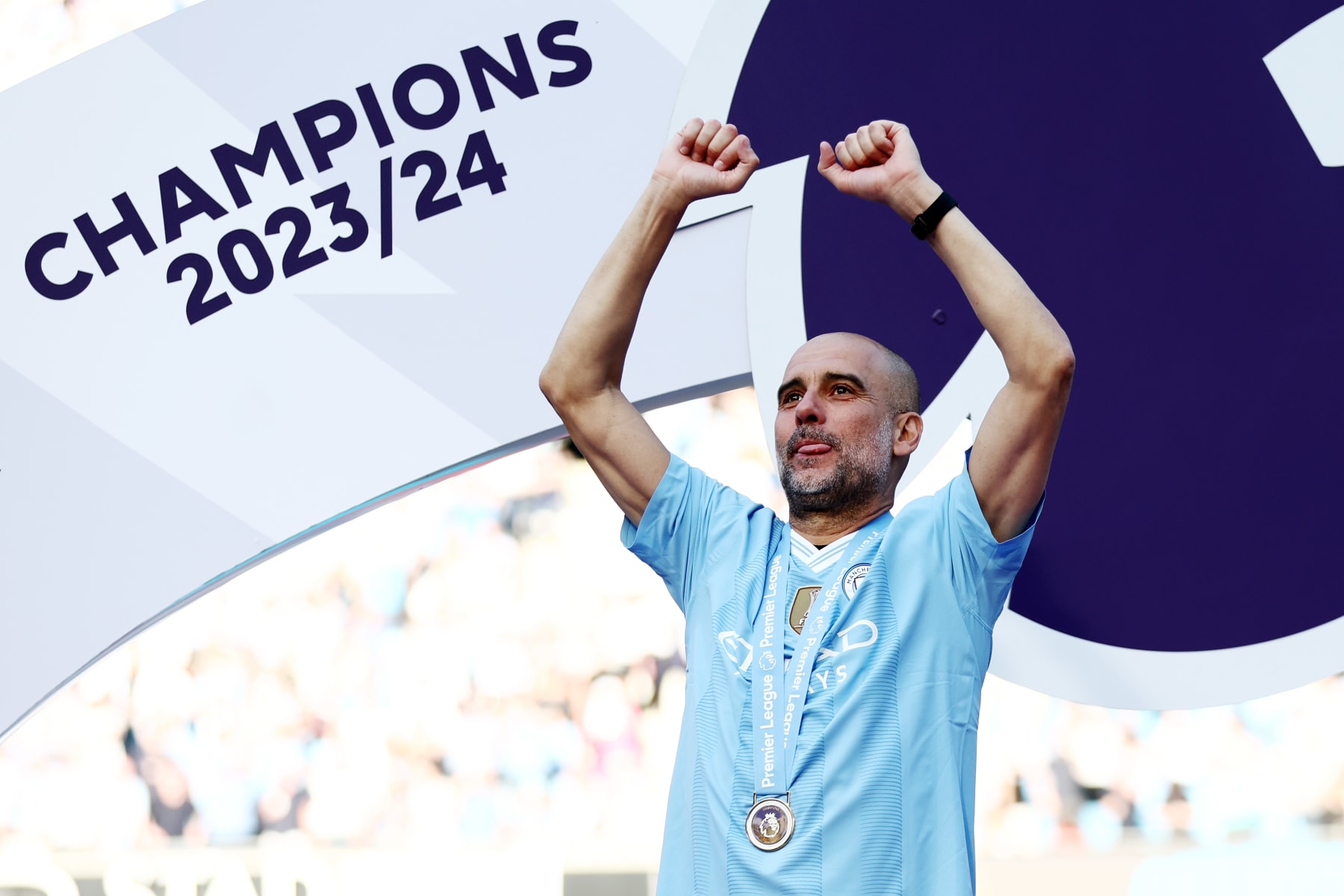 MANCHESTER, ENGLAND - MAY 19: Pep Guardiola, Manager of Manchester City, celebrates with his Winners Medal as he acknowledges the fans from the Winners Podium after the Premier League match between Manchester City and West Ham United at Etihad Stadium on May 19, 2024 in Manchester, England. (Photo by Naomi Baker/Getty Images) MANCHESTER, ENGLAND - MAY 19: Pep Guardiola, Manager of Manchester City, celebrates with his Winners Medal as he acknowledges the fans from the Winners Podium after the Premier League match between Manchester City and West Ham United at Etihad Stadium on May 19, 2024 in Manchester, England. (Photo by Naomi Baker/Getty Images)