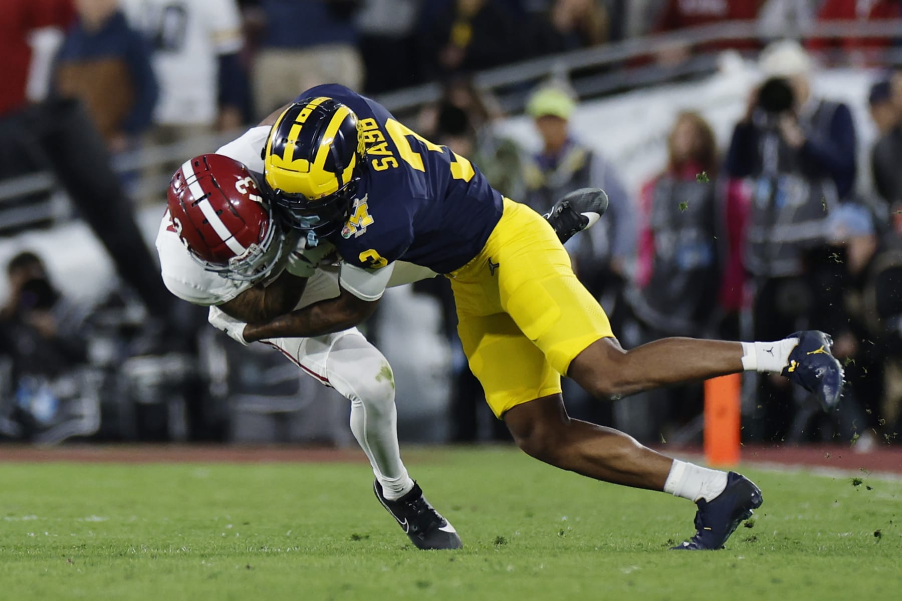 PASADENA, CALIFORNIA - JANUARY 01: Jermaine Burton #3 of the Alabama Crimson Tide runs with the ball while being tackled by Keon Sabb #3 of the Michigan Wolverines in the fourth quarter during the CFP Semifinal Rose Bowl Game at Rose Bowl Stadium on January 01, 2024 in Pasadena, California. (Photo by Kevork Djansezian/Getty Images)