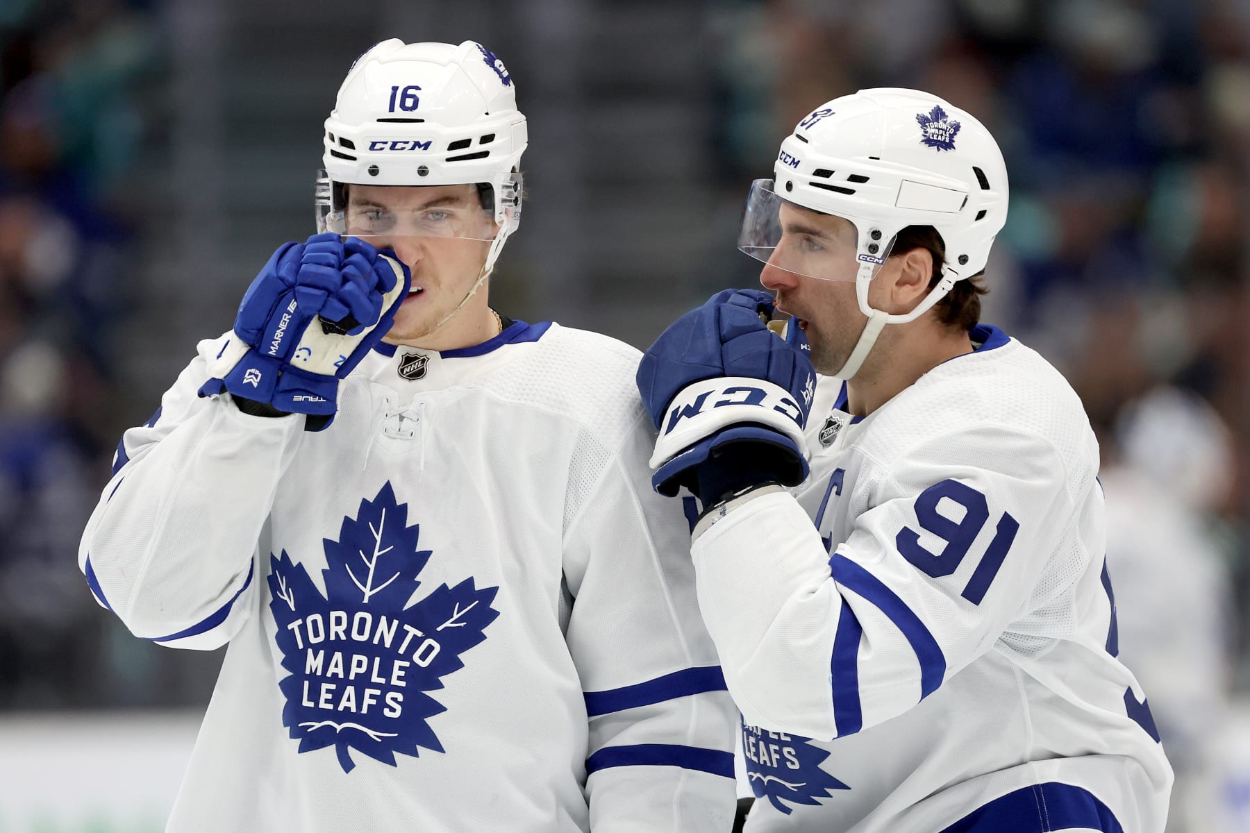 SEATTLE, WASHINGTON - JANUARY 21: Mitchell Marner #16 and John Tavares #91 of the Toronto Maple Leafs talk during the first period against the Seattle Kraken at Climate Pledge Arena on January 21, 2024 in Seattle, Washington. (Photo by Steph Chambers/Getty Images)