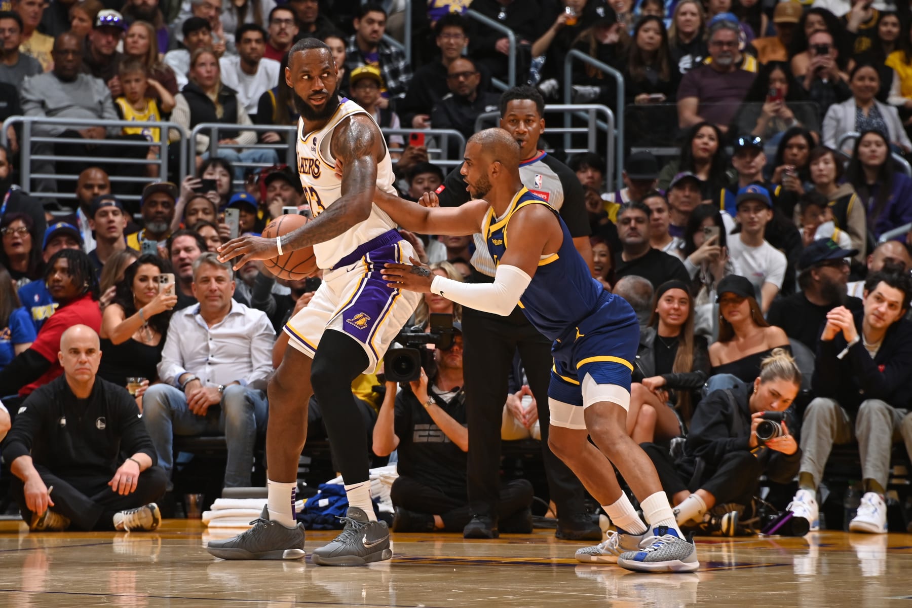 LOS ANGELES, CA - MARCH 16: LeBron James #23 of the Los Angeles Lakers and Chris Paul #3 of the Golden State Warriors look on during the game on March 16, 2024 at Crypto.Com Arena in Los Angeles, California. NOTE TO USER: User expressly acknowledges and agrees that, by downloading and/or using this Photograph, user is consenting to the terms and conditions of the Getty Images License Agreement. Mandatory Copyright Notice: Copyright 2024 NBAE (Photo by Andrew D. Bernstein/NBAE via Getty Images)