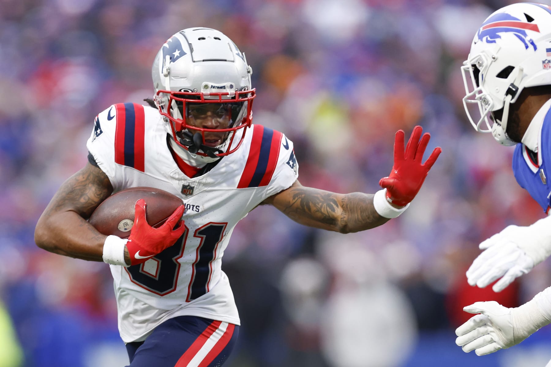 Orchard Park, NY - December 31: New England Patriots WR Demario Douglas looks to stiff arm a defender in the second half. The Patriots lost to the Buffalo Bills, 27-21. (Photo by Danielle Parhizkaran/The Boston Globe via Getty Images)