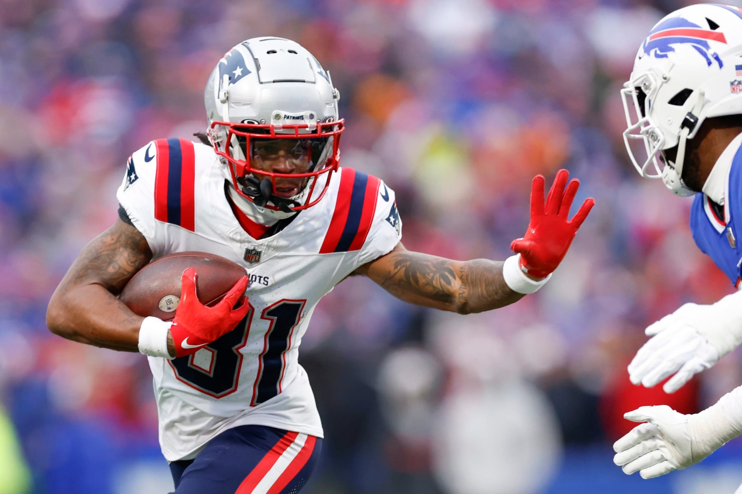 Orchard Park, NY - December 31: New England Patriots WR Demario Douglas looks to stiff arm a defender in the second half. The Patriots lost to the Buffalo Bills, 27-21. (Photo by Danielle Parhizkaran/The Boston Globe via Getty Images)