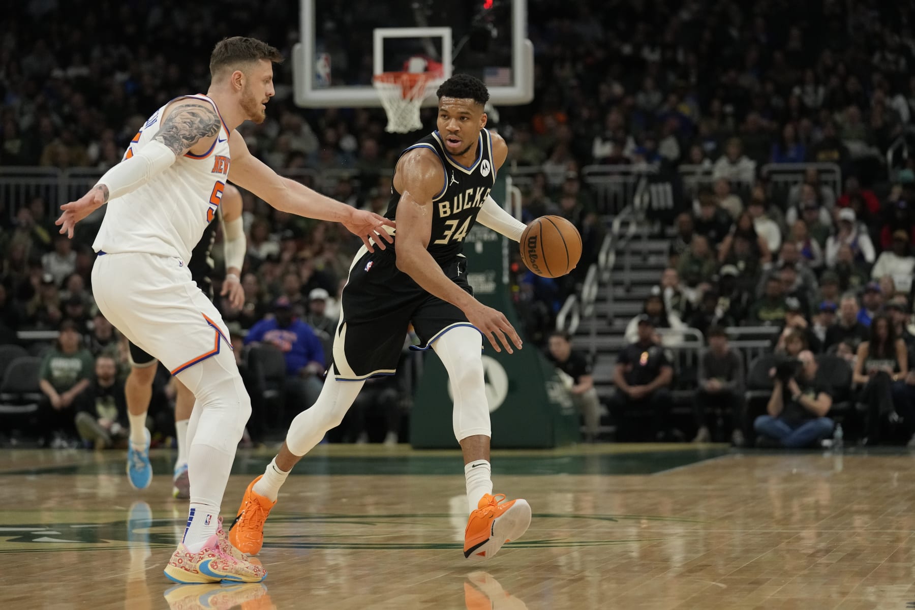 MILWAUKEE, WISCONSIN - APRIL 07: Giannis Antetokounmpo #34 of the Milwaukee Bucks dribbles the ball against Isaiah Hartenstein #55 of the New York Knicks during the first half at Fiserv Forum on April 07, 2024 in Milwaukee, Wisconsin. NOTE TO USER: User expressly acknowledges and agrees that, by downloading and or using this photograph, User is consenting to the terms and conditions of the Getty Images License Agreement. (Photo by Patrick McDermott/Getty Images)