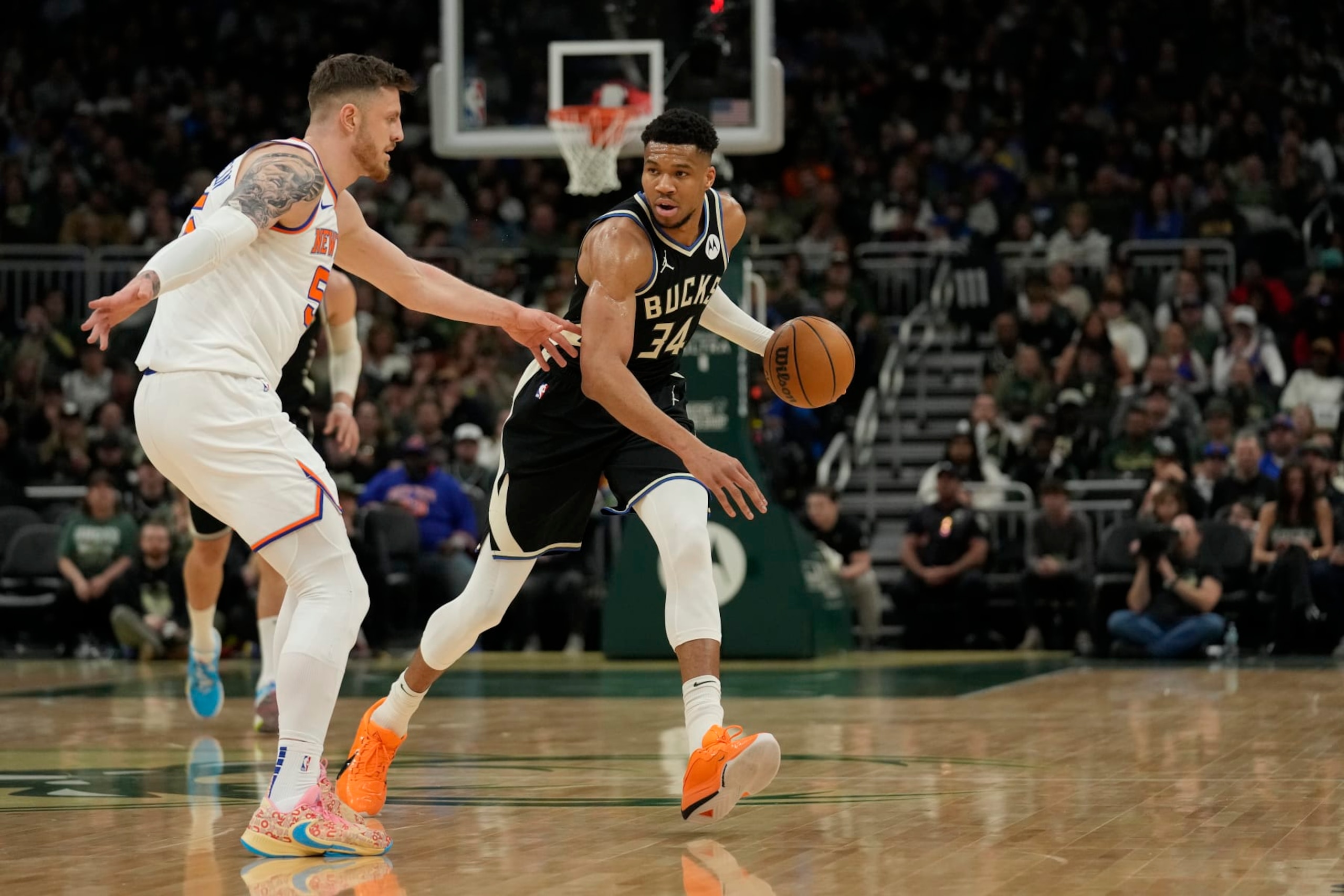 MILWAUKEE, WISCONSIN - APRIL 07: Giannis Antetokounmpo #34 of the Milwaukee Bucks dribbles the ball against Isaiah Hartenstein #55 of the New York Knicks during the first half at Fiserv Forum on April 07, 2024 in Milwaukee, Wisconsin. NOTE TO USER: User expressly acknowledges and agrees that, by downloading and or using this photograph, User is consenting to the terms and conditions of the Getty Images License Agreement. (Photo by Patrick McDermott/Getty Images)