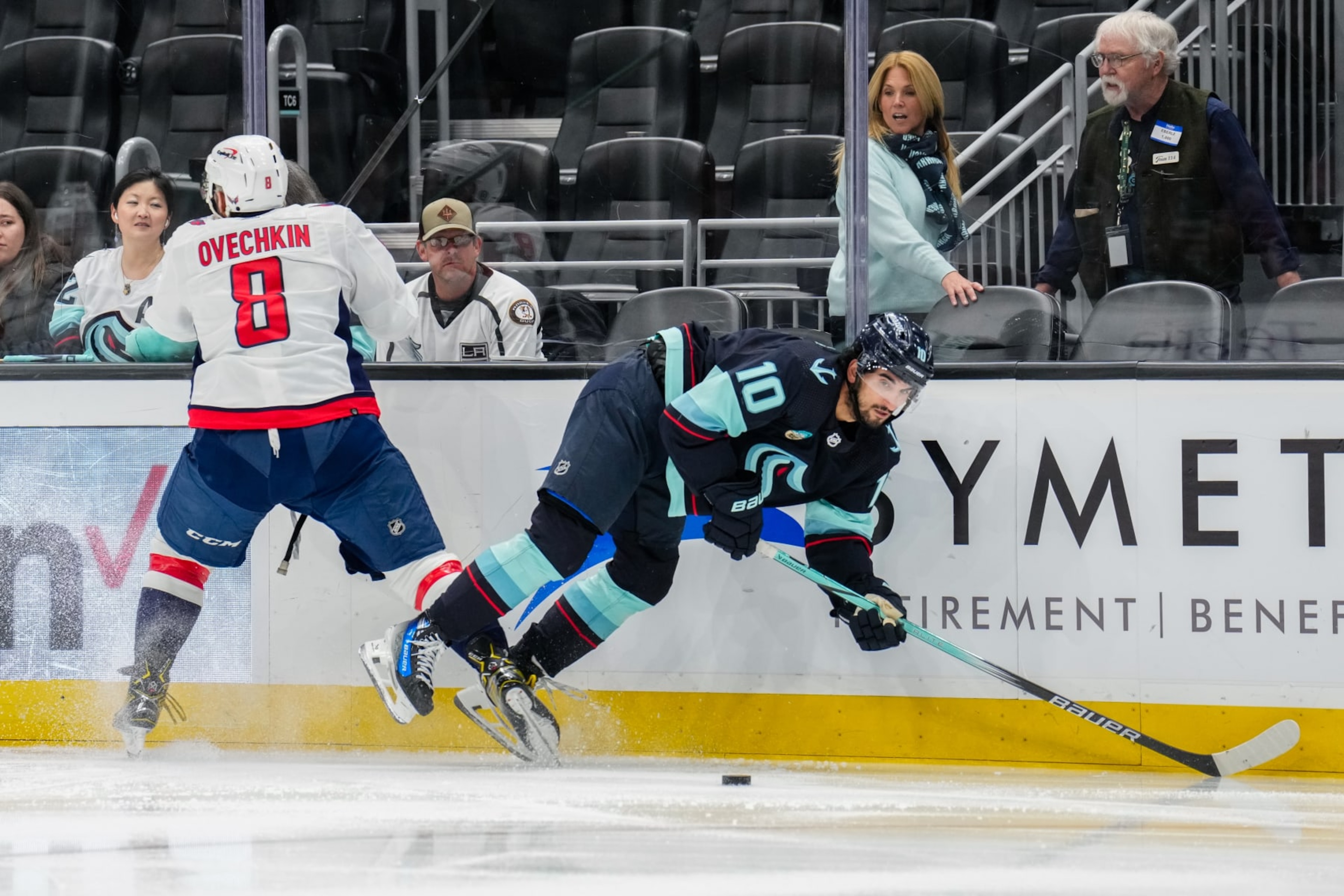 SEATTLE, WASHINGTON - MARCH 14: Matty Beniers #10 of the Seattle Kraken reacts to a check from Alex Ovechkin #8 of the Washington Capitals during the second period of a game at Climate Pledge Arena on March 14, 2024 in Seattle, Washington. (Photo by Christopher Mast/NHLI via Getty Images) SEATTLE, WASHINGTON - MARCH 14: Matty Beniers #10 of the Seattle Kraken reacts to a check from Alex Ovechkin #8 of the Washington Capitals during the second period of a game at Climate Pledge Arena on March 14, 2024 in Seattle, Washington. (Photo by Christopher Mast/NHLI via Getty Images)