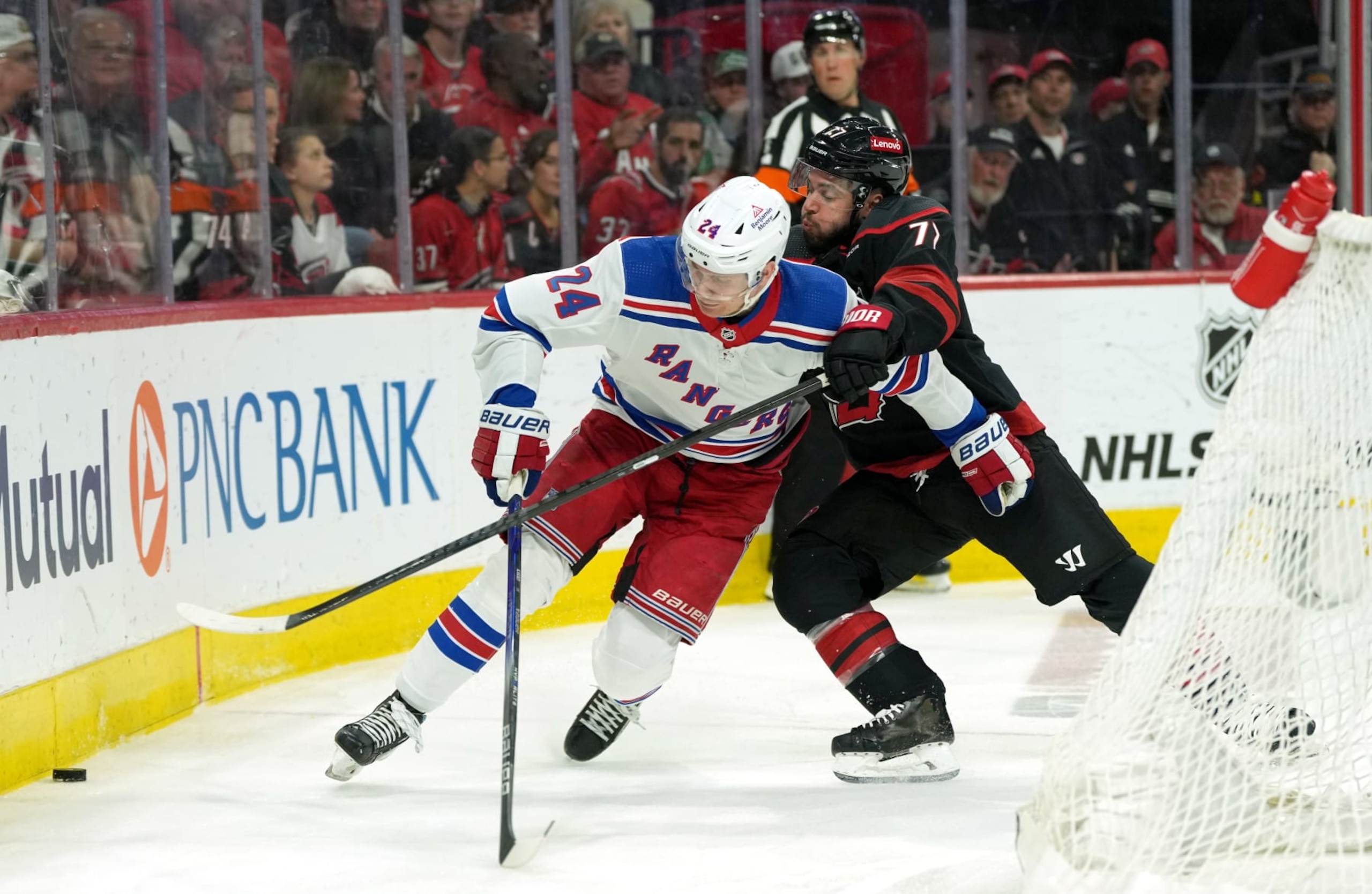 RALEIGH, NORTH CAROLINA - MAY 16: Kaapo Kakko #24 of the New York Rangers and Tony DeAngelo #77 of the Carolina Hurricanes battle during the first period in Game Six of the Second Round of the 2024 Stanley Cup Playoffs at PNC Arena on May 16, 2024 in Raleigh, North Carolina.  (Photo by Grant Halverson/Getty Images)