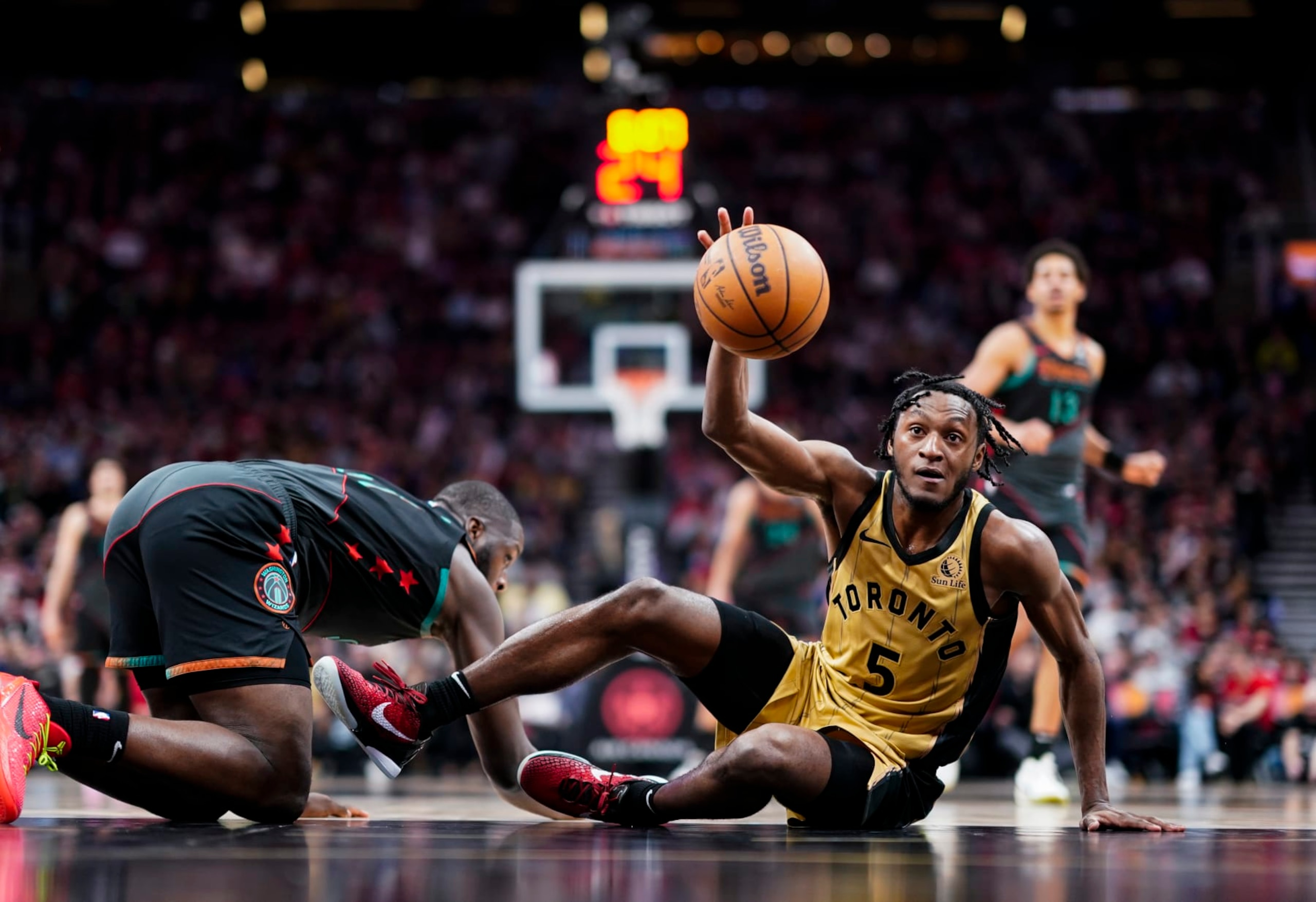 TORONTO, ON - APRIL 7: Immanuel Quickley #5 of the Toronto Raptors battles for a loose ball against the Washington Wizards during the second half of their basketball game at the Scotiabank Arena on April 7, 2024 in Toronto, Ontario, Canada. NOTE TO USER: User expressly acknowledges and agrees that, by downloading and/or using this Photograph, user is consenting to the terms and conditions of the Getty Images License Agreement. (Photo by Mark Blinch/Getty Images)