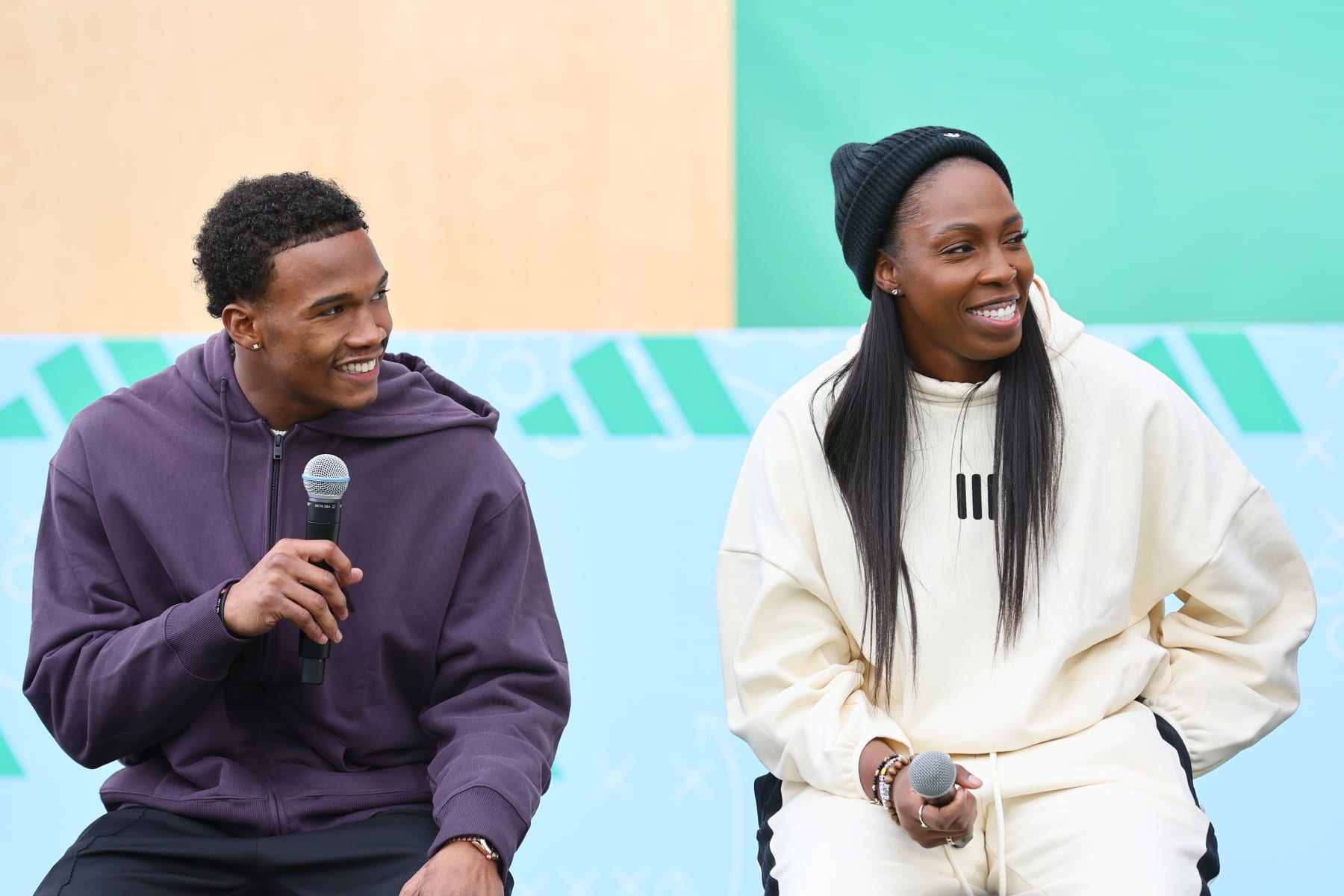 LAS VEGAS, NEVADA - FEBRUARY 09: (L-R) Garrett Wilson and Chelsea Gray speak in a huddle on the field as adidas debuts its brand campaign with a star-studded roster of athletes at Resorts World Las Vegas on February 09, 2024 in Las Vegas, Nevada. (Photo by Joe Scarnici/Getty Images for adidas)