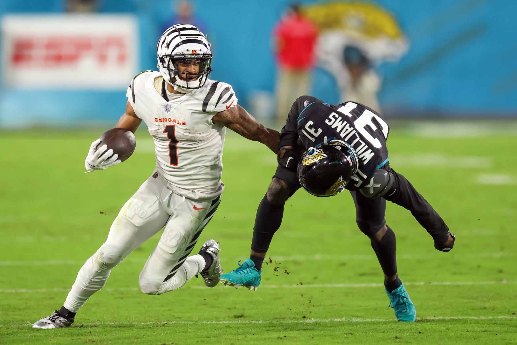 JACKSONVILLE, FLORIDA - DECEMBER 4: JaMarr Chase #1 of the Cincinnati Bengals defends against a tackle attempt by Darious Williams #31 of the Jacksonville Jaguars at EverBank Field on December 4, 2023 in Jacksonville, Florida. (Photo by Mike Carlson/Getty Images)