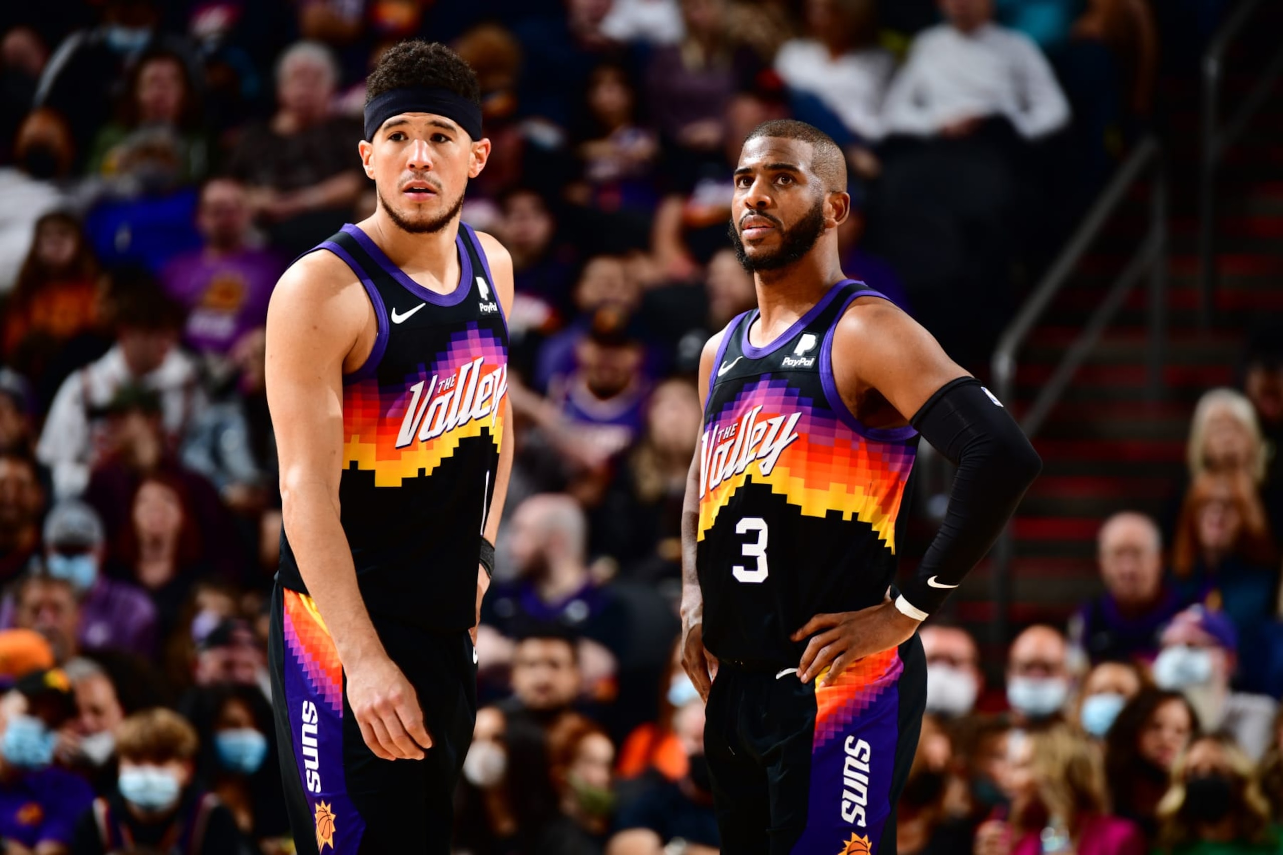 PHOENIX, AZ - FEBRUARY 12: Devin Booker #1 and Chris Paul #3 of the Phoenix Suns look on during the game against the Orlando Magic on February 12, 2022 at Footprint Center in Phoenix, Arizona. NOTE TO USER: User expressly acknowledges and agrees that, by downloading and or using this photograph, user is consenting to the terms and conditions of the Getty Images License Agreement. Mandatory Copyright Notice: Copyright 2022 NBAE (Photo by Barry Gossage/NBAE via Getty Images)