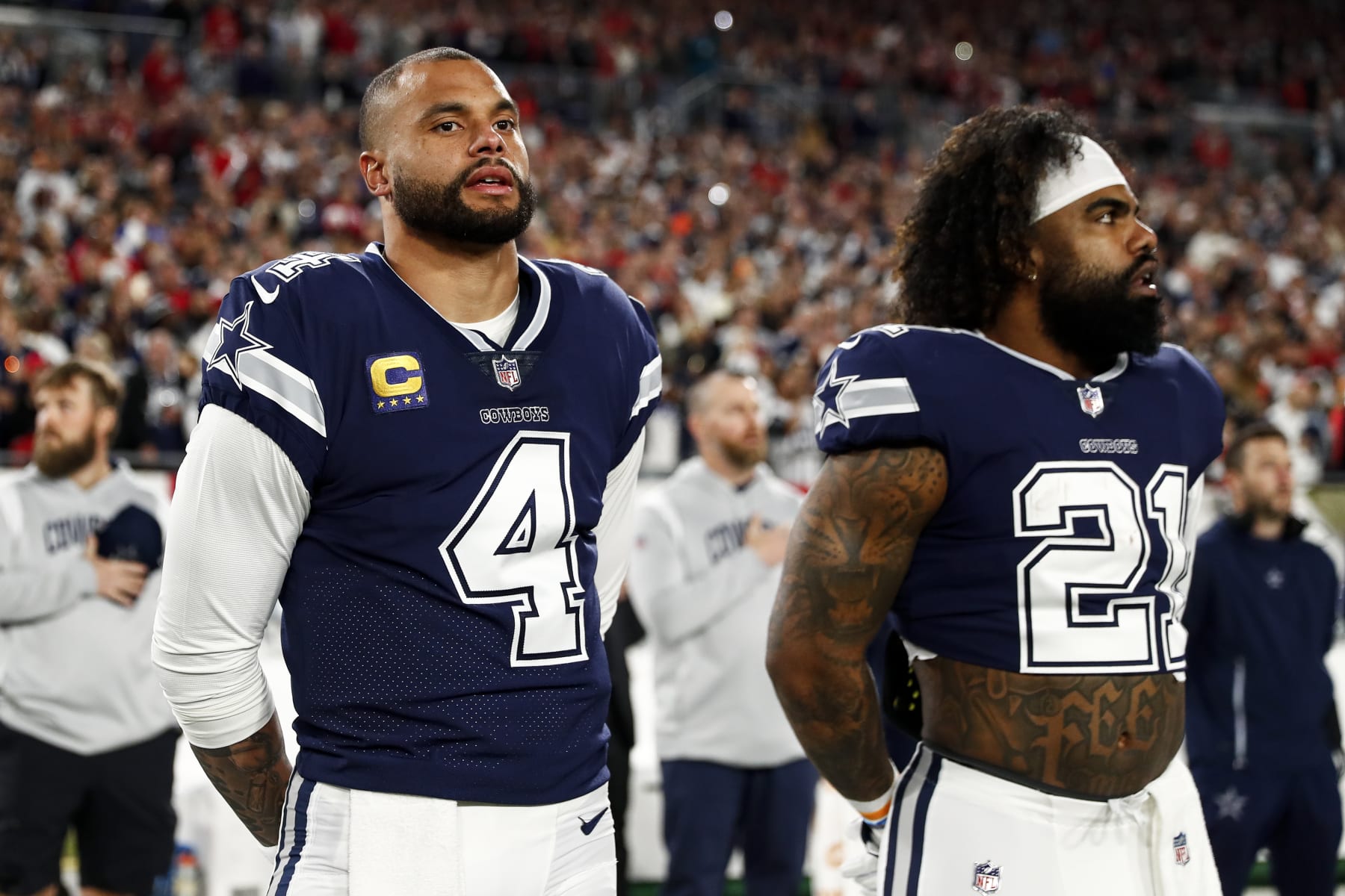 TAMPA, FL - JANUARY 16: Dak Prescott #4 and Ezekiel Elliott #21 of the Dallas Cowboys stand on the sidelines during the national anthem prior to an NFL wild card playoff football game against the Tampa Bay Buccaneers at Raymond James Stadium on January 16, 2023 in Tampa, Florida. (Photo by Kevin Sabitus/Getty Images)