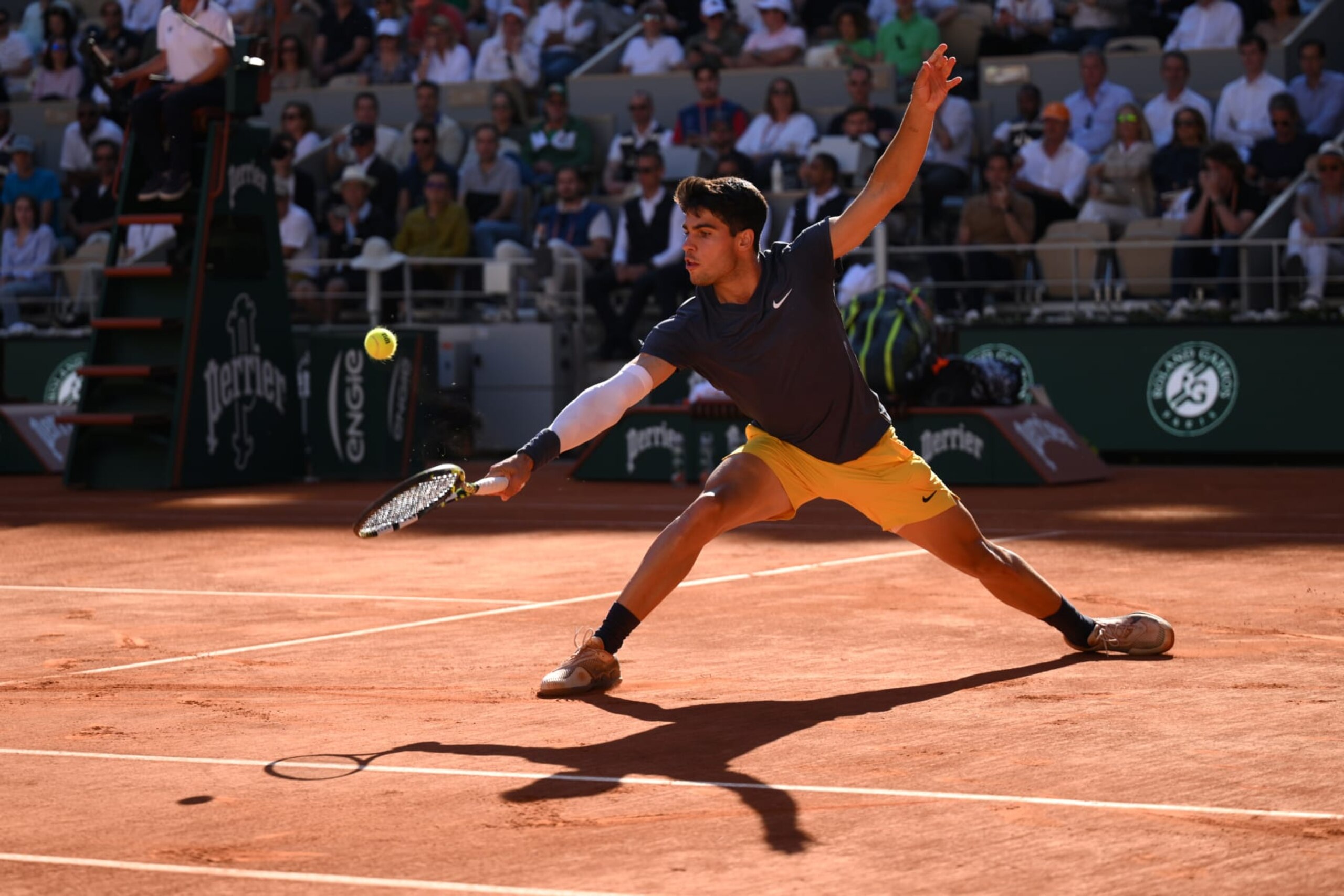 PARIS, FRANCE - JUNE 07: Carlos Alcaraz of Spain stretches for a backhand against Jannik Sinner of Italy during the Men's Singles Semi-Final match during Day Thirteen of the 2024 French Open at Roland Garros on June 07, 2024 in Paris, France. (Photo by Tim Goode/Getty Images)
