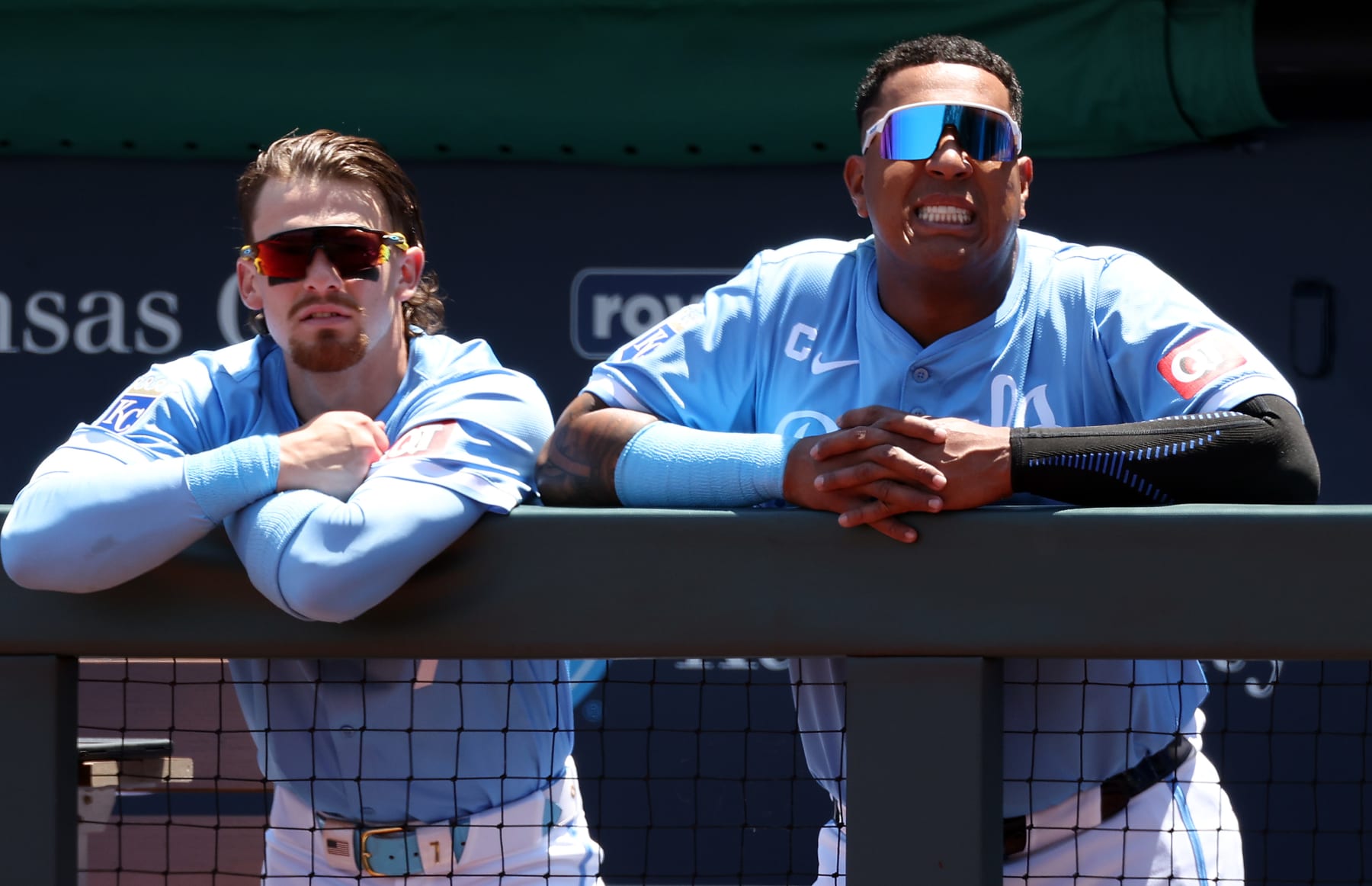 KANSAS CITY, MISSOURI - MAY 22:  Bobby Witt Jr. #7 and Salvador Perez #13 of the Kansas City Royals watch from the dugout during the game against the Detroit Tigers at Kauffman Stadium on May 22, 2024 in Kansas City, Missouri. (Photo by Jamie Squire/Getty Images)