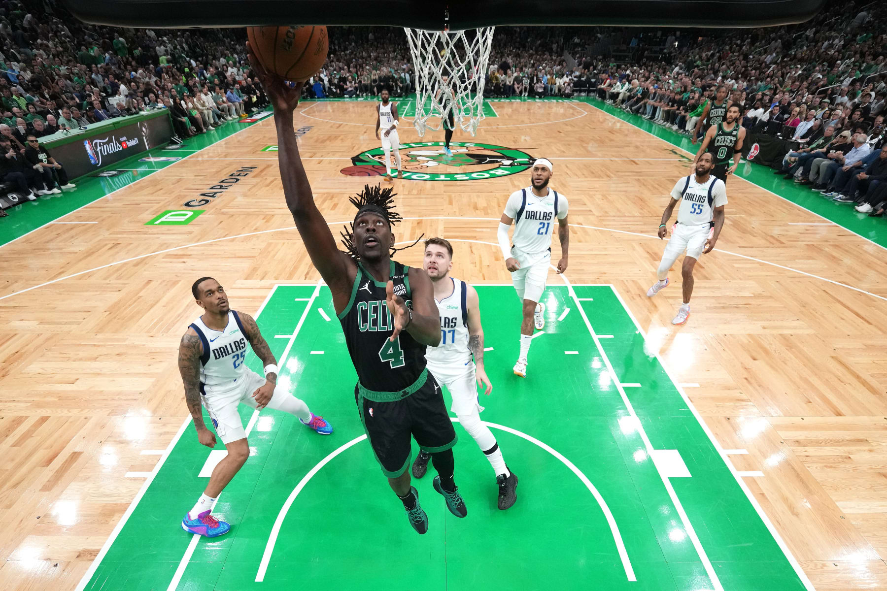 BOSTON, MASSACHUSETTS - JUNE 09: Jrue Holiday #4 of the Boston Celtics shoots the ball past P.J. Washington #25 and Luka Doncic #77 of the Dallas Mavericks during the first quarter in Game Two of the 2024 NBA Finals at TD Garden on June 09, 2024 in Boston, Massachusetts. NOTE TO USER: User expressly acknowledges and agrees that, by downloading and or using this photograph, User is consenting to the terms and conditions of the Getty Images License Agreement. (Photo by Peter Casey - Pool/Getty Images)