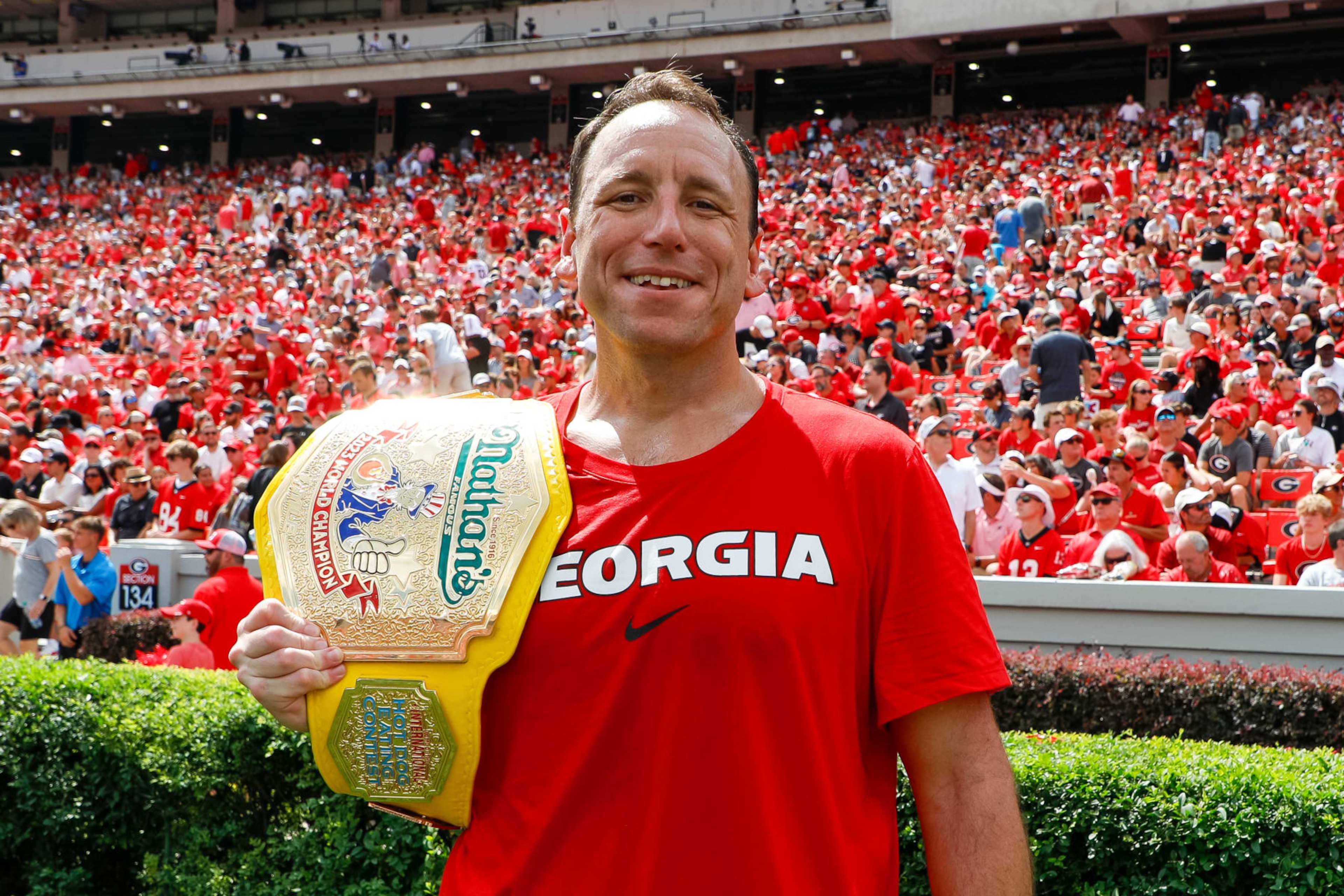 ATHENS, GEORGIA - SEPTEMBER 9: Competitive eater Joey Chestnut poses with his mustard yellow championship belt during a game between the Georgia Bulldogs and the Ball State Cardinals at Sanford Stadium on September 9, 2023 in Athens, Georgia. (Photo by Brandon Sloter/Image Of Sport/Getty Images)