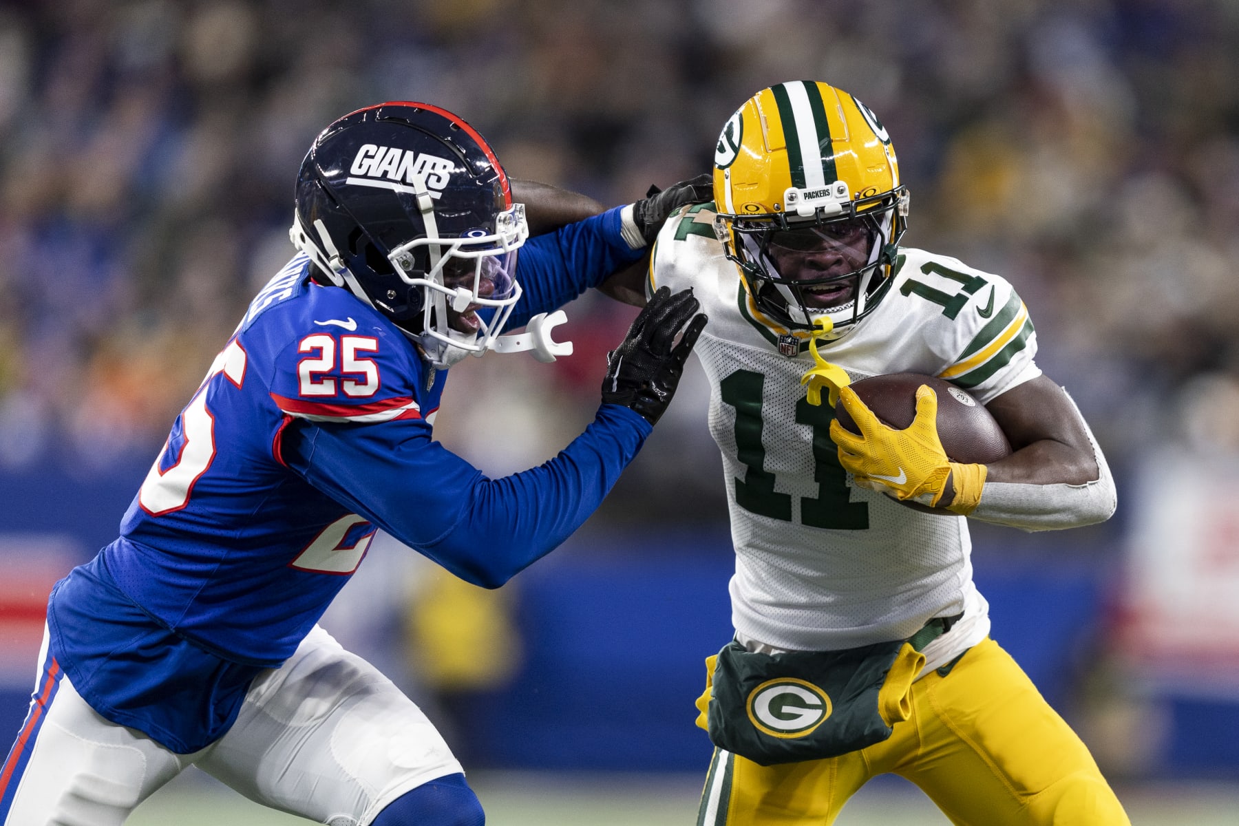 EAST RUTHERFORD, NEW JERSEY - DECEMBER 11: Jayden Reed #11 of the Green Bay Packers stiff arms Deonte Banks #25 of the New York Giants during an NFL football game between the New York Giants and the Green Bay Packers at MetLife Stadium on December 11, 2023 in East Rutherford, New Jersey. (Photo by Michael Owens/Getty Images)