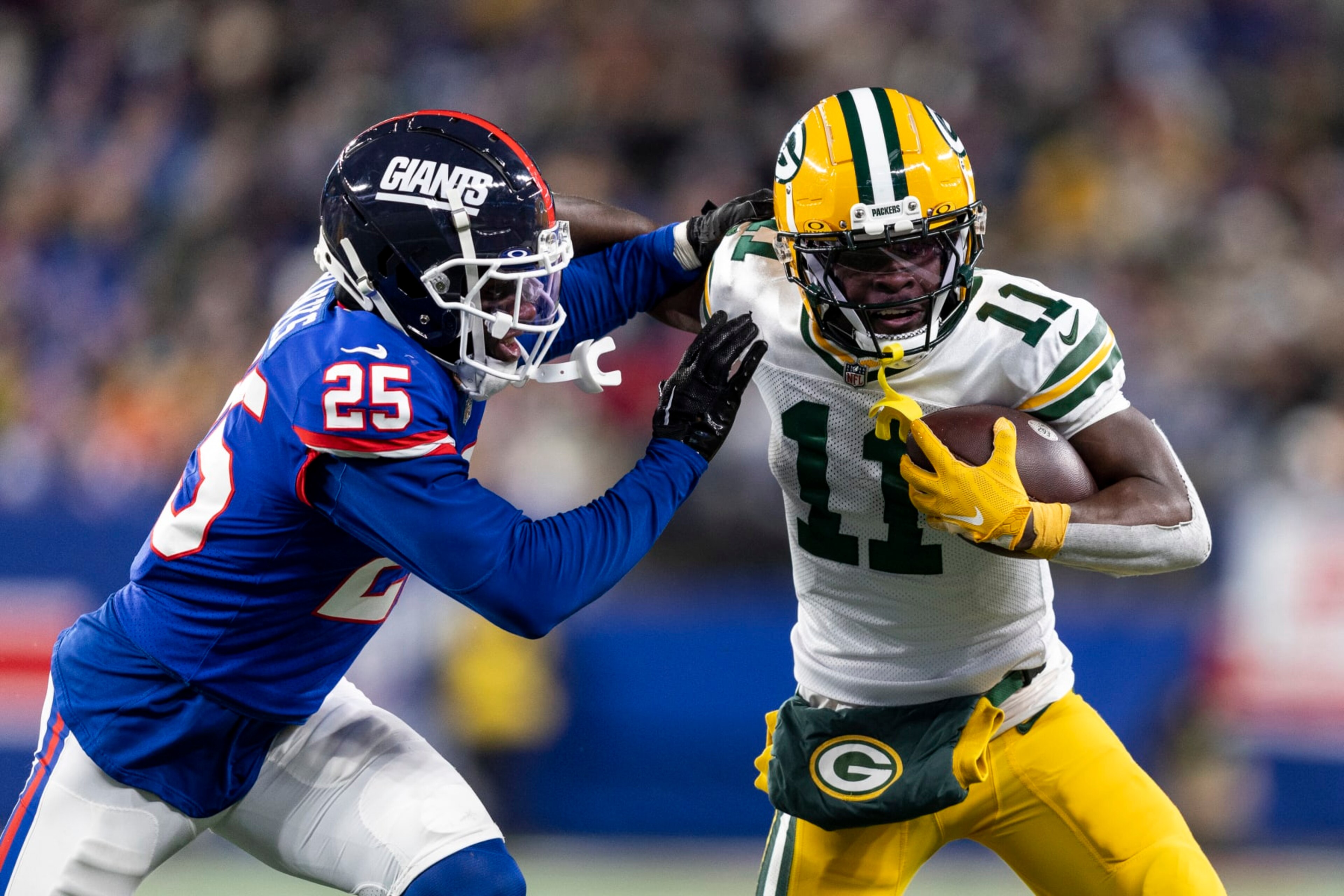 EAST RUTHERFORD, NEW JERSEY - DECEMBER 11: Jayden Reed #11 of the Green Bay Packers stiff arms Deonte Banks #25 of the New York Giants during an NFL football game between the New York Giants and the Green Bay Packers at MetLife Stadium on December 11, 2023 in East Rutherford, New Jersey. (Photo by Michael Owens/Getty Images) EAST RUTHERFORD, NEW JERSEY - DECEMBER 11: Jayden Reed #11 of the Green Bay Packers stiff arms Deonte Banks #25 of the New York Giants during an NFL football game between the New York Giants and the Green Bay Packers at MetLife Stadium on December 11, 2023 in East Rutherford, New Jersey. (Photo by Michael Owens/Getty Images)