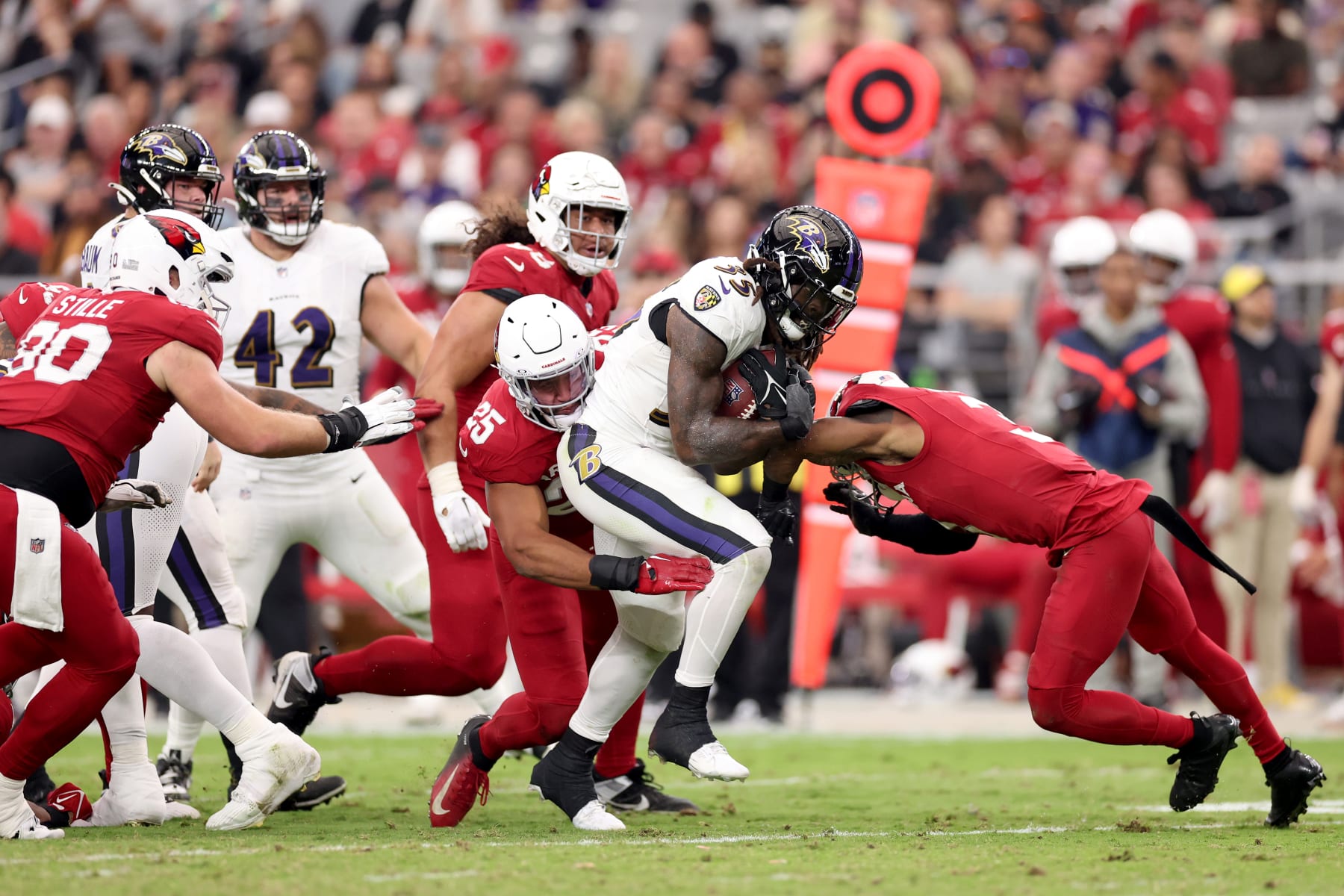 GLENDALE, ARIZONA - OCTOBER 29: Zaven Collins #25 of the Arizona Cardinals and Budda Baker #3 of the Arizona Cardinals tackle Gus Edwards #35 of the Baltimore Ravens during the fourth quarter at State Farm Stadium on October 29, 2023 in Glendale, Arizona. (Photo by Christian Petersen/Getty Images)